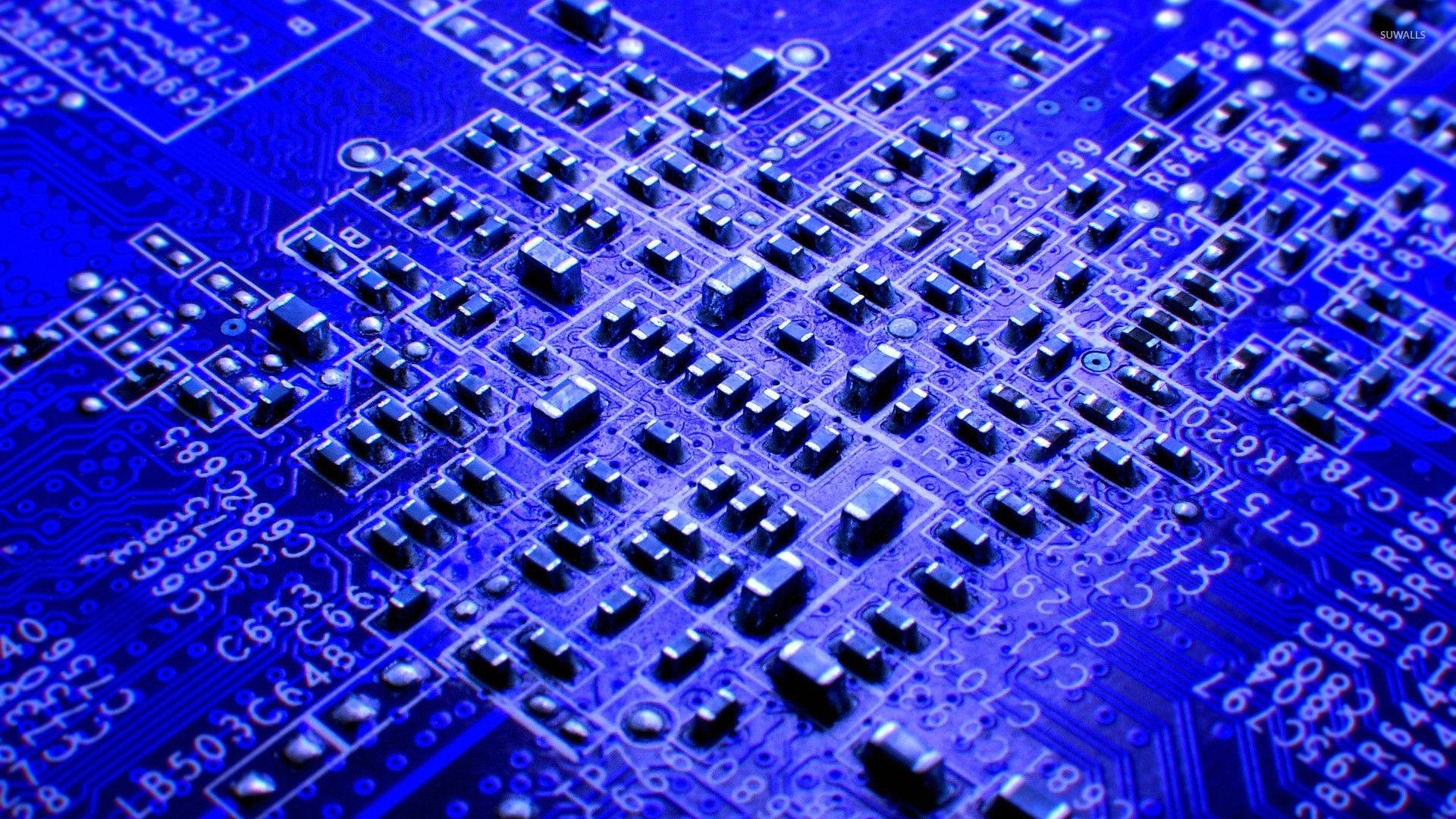 Circuit 桌布 壁紙 — 藍色電路板的特寫，具有複雜的路徑和電子元件，在戲劇性的燈光下。