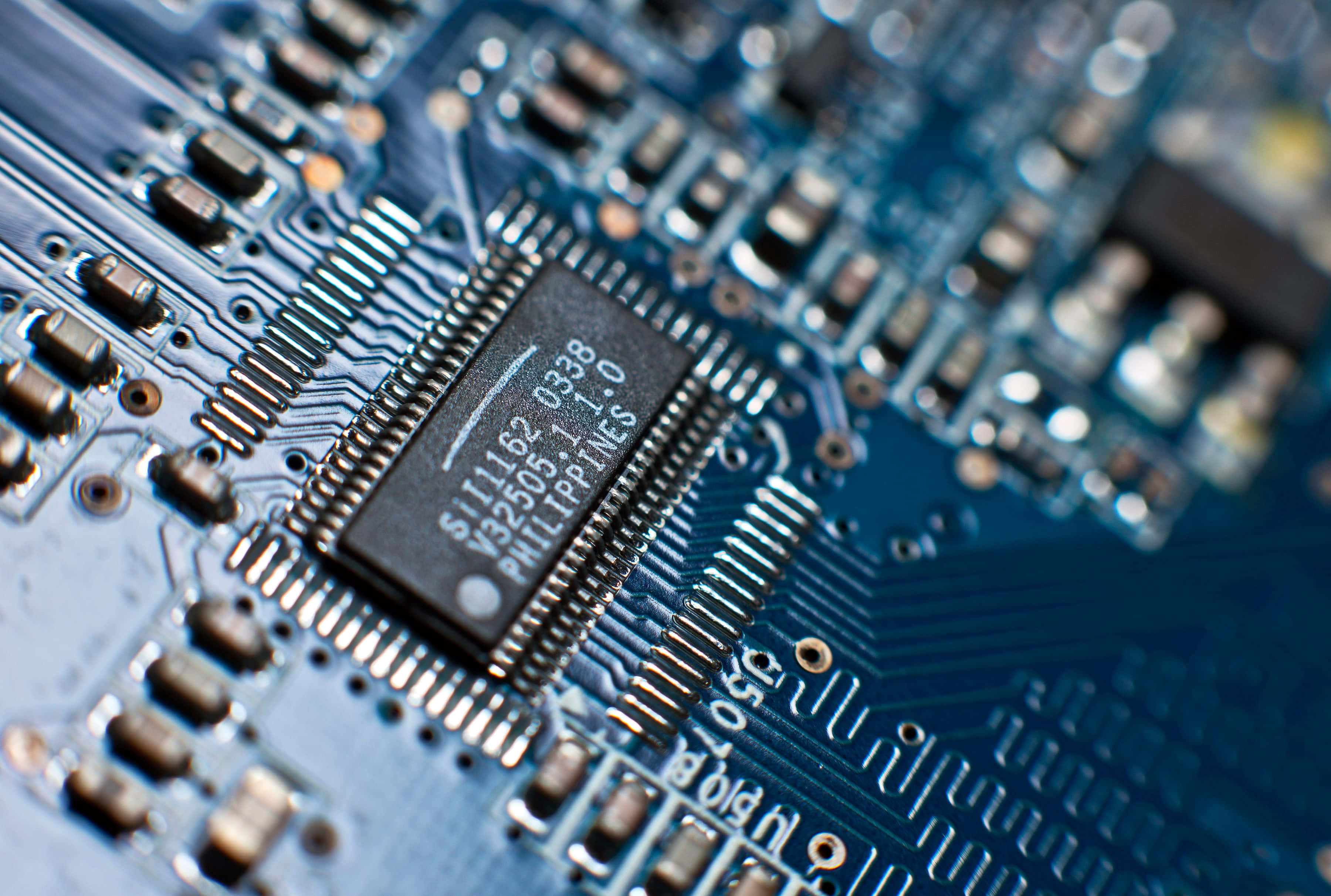 Electronic Components 桌布 壁紙 — 藍色電路板的特寫微距鏡頭，黑色微晶片標有S11182，顯著居中。