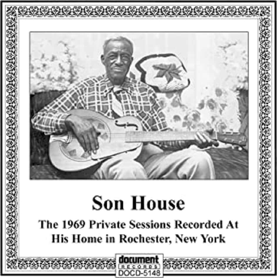 Legend 桌布 壁紙 — 藍調音樂家 Son House 坐著手持共鳴吉他的黑白肖像，帶有華麗框架及下方文字。