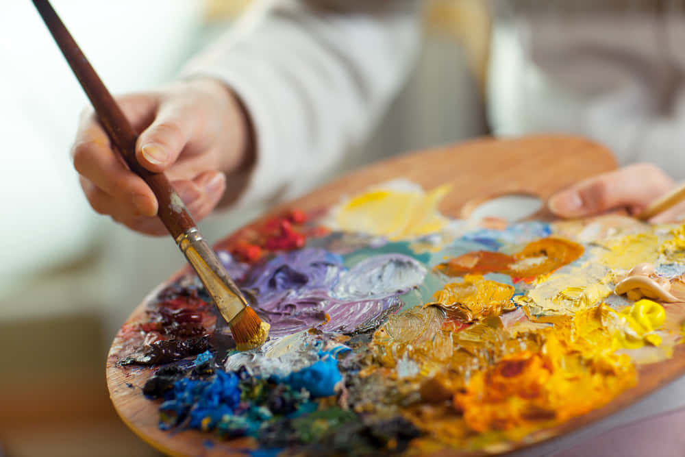 Painting 桌布 壁紙 — 藝術家的手在木製調色板上用畫筆混合鮮豔的壓克力顏料的特寫。