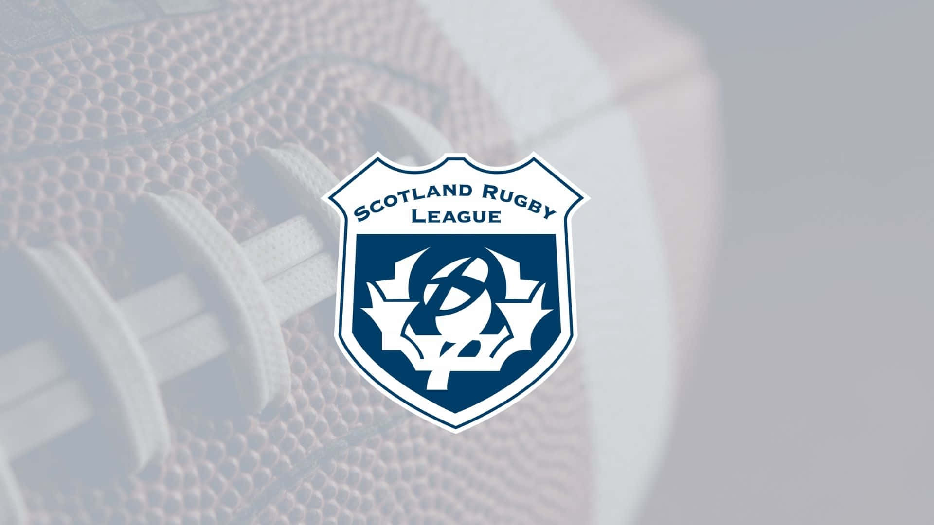 Scotland Rugby 桌布 壁紙 — 蘇格蘭橄欖球聯賽標誌居中於模糊的橄欖球背景上，帶有白色鞋帶和紋理皮革。