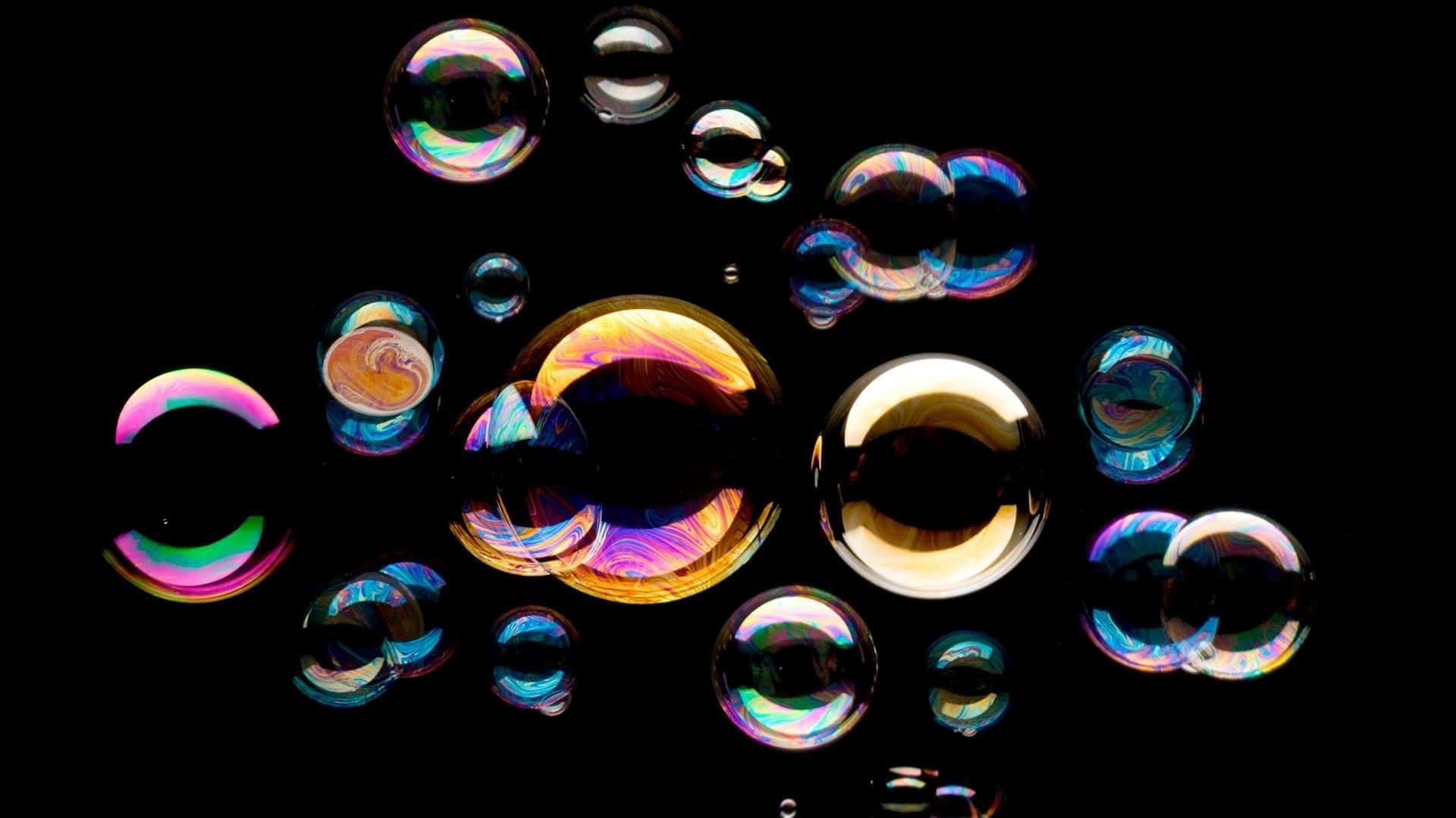 Bubble 桌布 壁紙 — 虹彩肥皂泡在黑色背景上漂浮，反射出鮮豔的彩虹色彩，呈現迷人的景象。