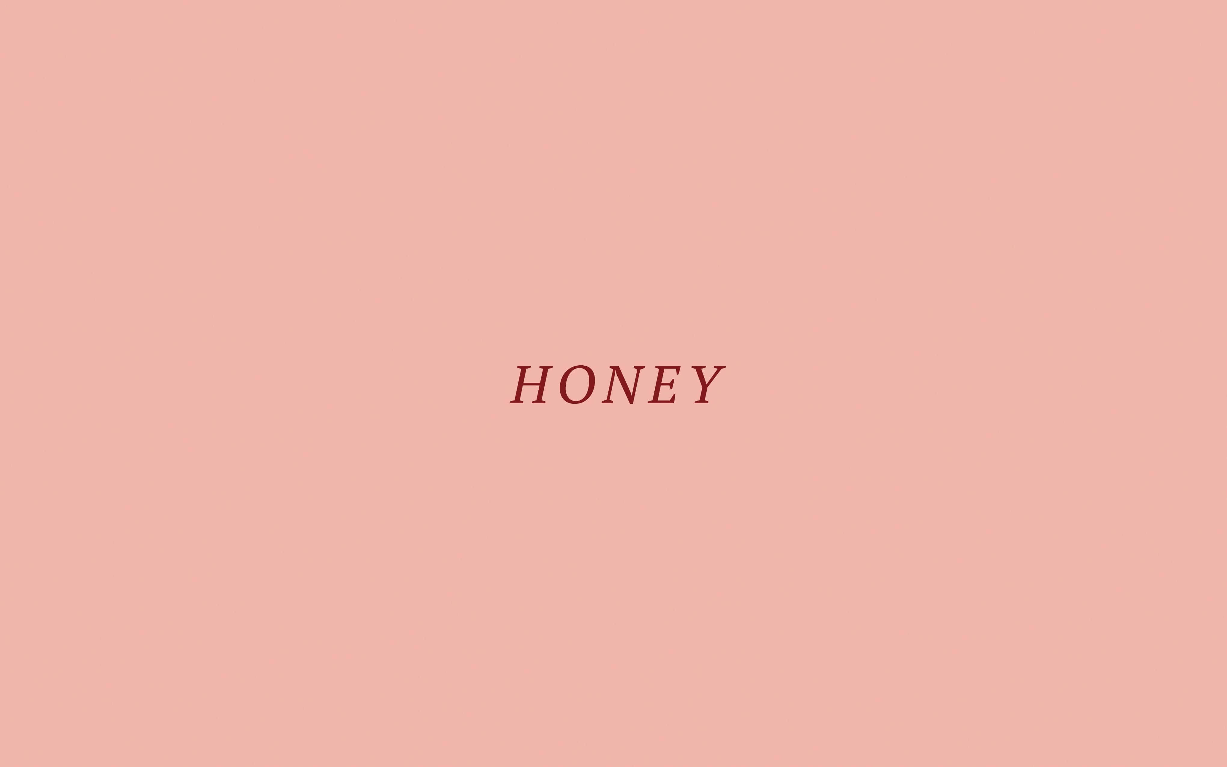 honey 桌布 壁紙 — 「蜂蜜」一詞以優雅的紅色襯線字體居中顯示在柔和的桃色背景上。
