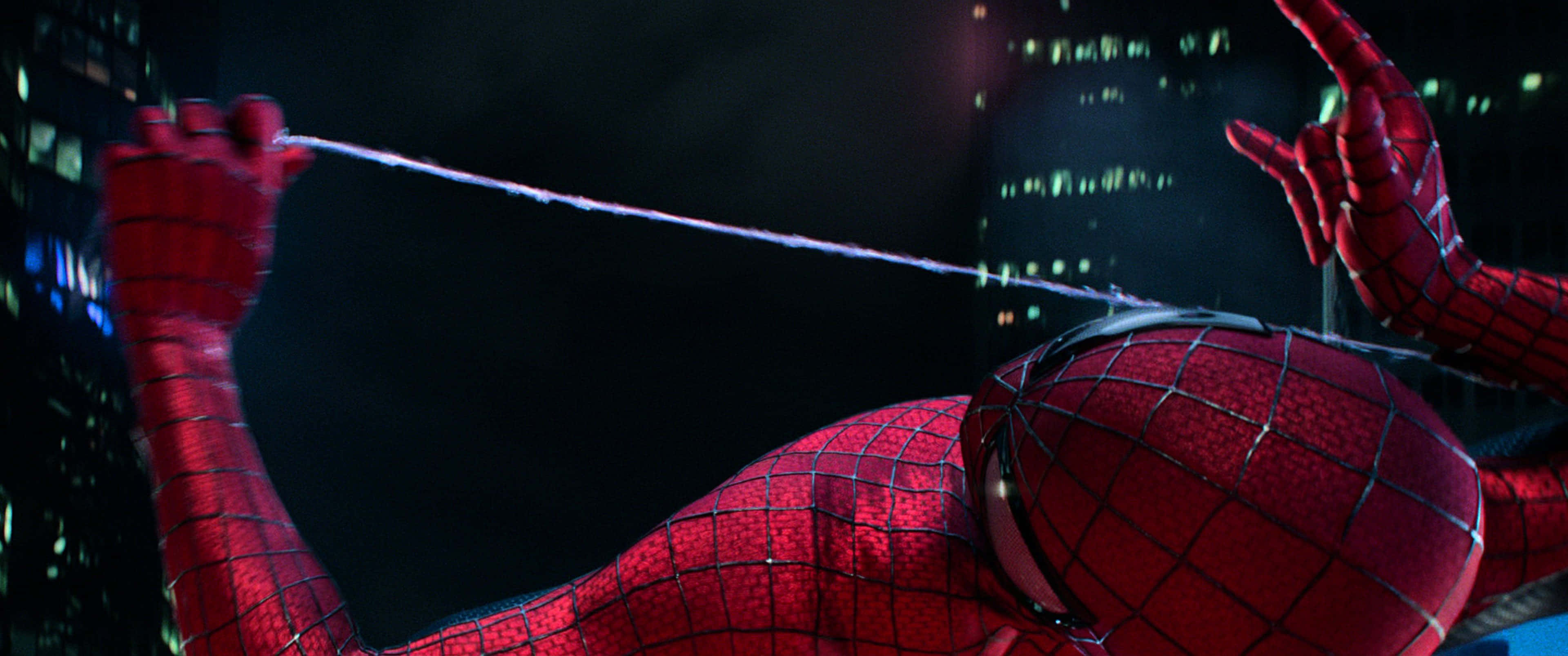 Spider Man Trilogy 桌布 壁紙 — 蜘蛛人在夜晚穿過霓虹燈閃爍的城市景觀，從手中向黑暗的天空發射蜘蛛絲。