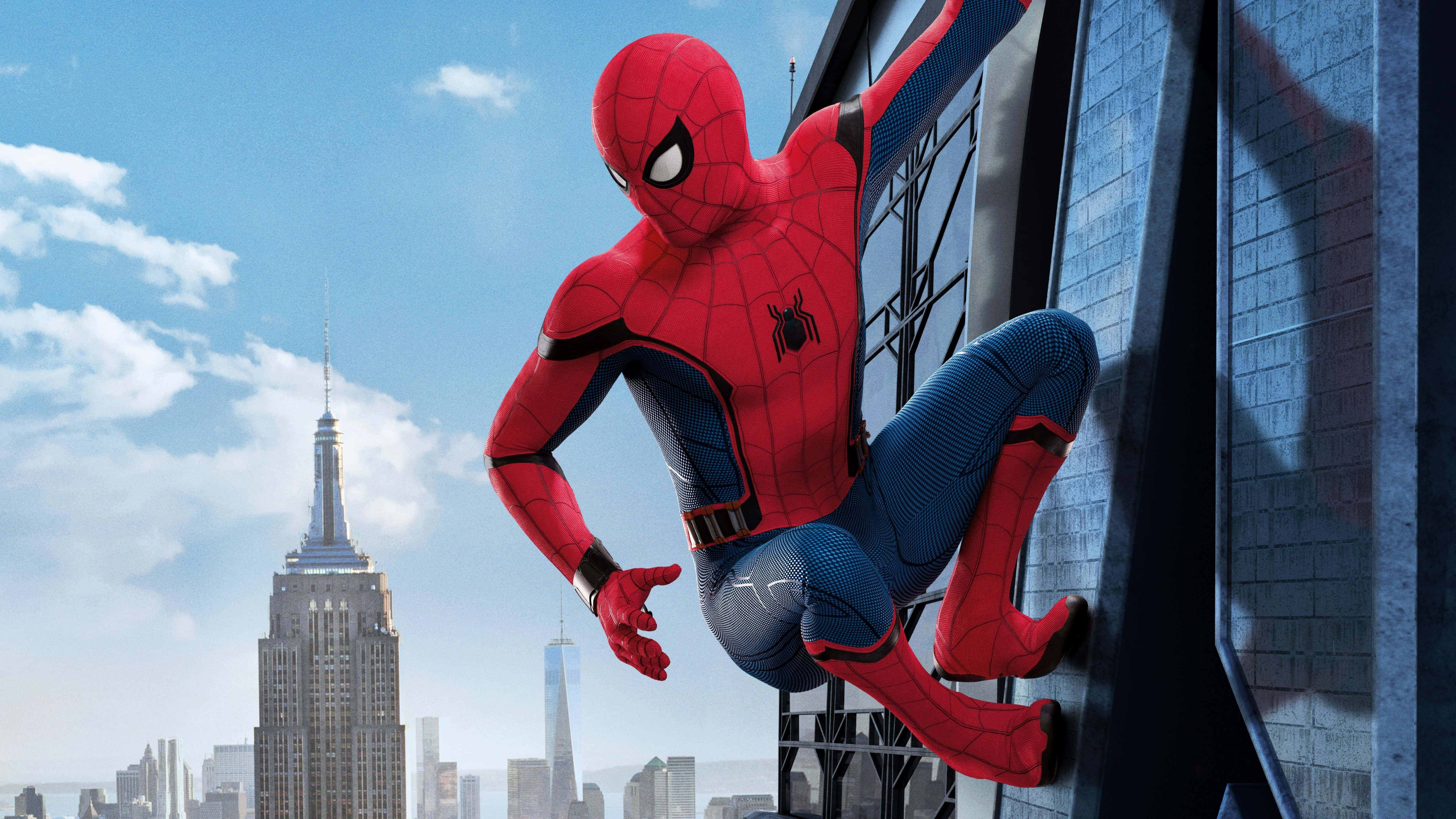 Spider Man No Way Home 桌布 壁紙 — 蜘蛛人在晴朗藍天背景下攀爬摩天大樓，遠處可見帝國大廈。