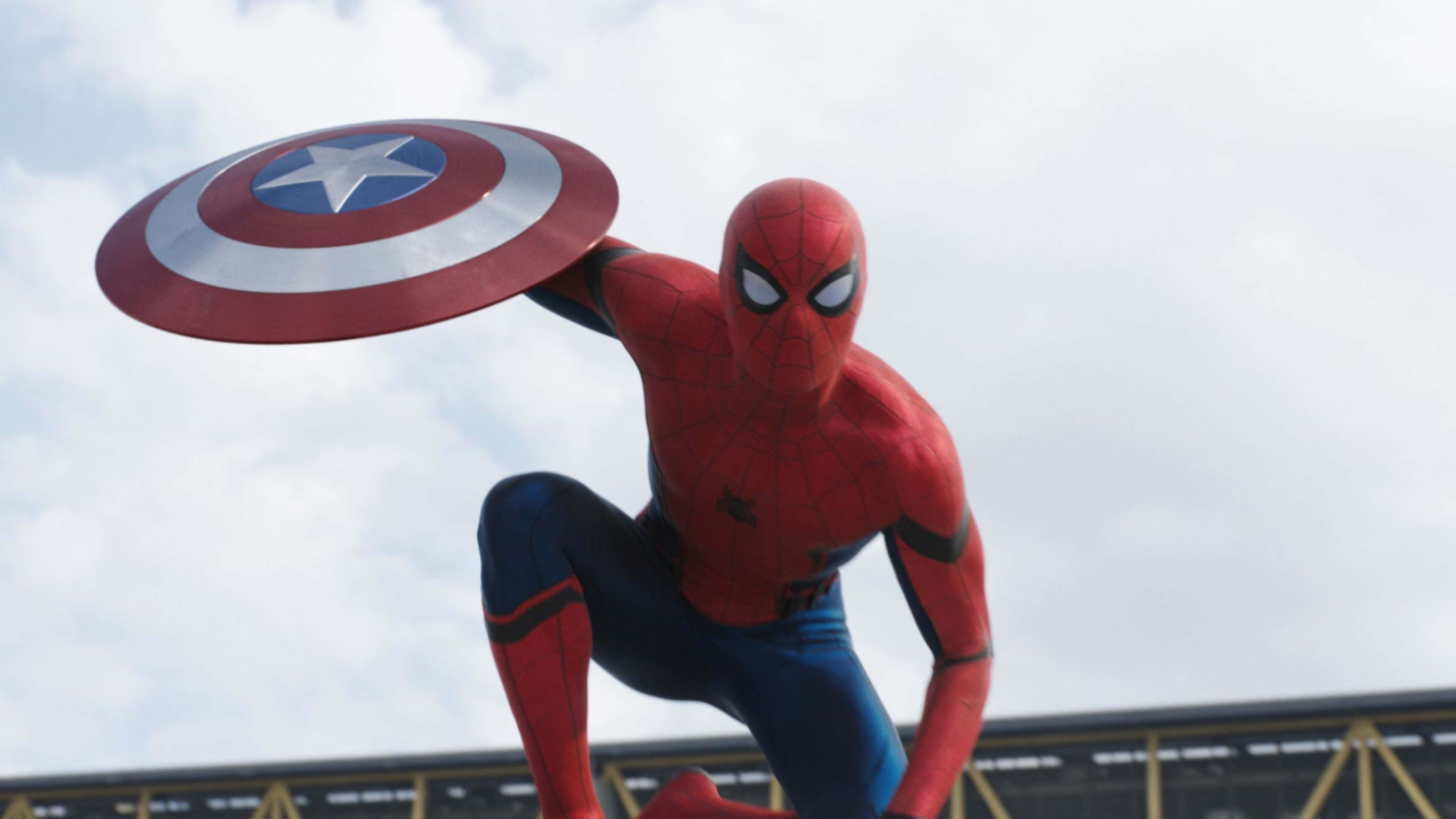 4K Captain America 桌布 壁紙 — 蜘蛛人穿著紅藍戰衣，動態地蹲下，手持美國隊長的盾牌，背景是陰天。