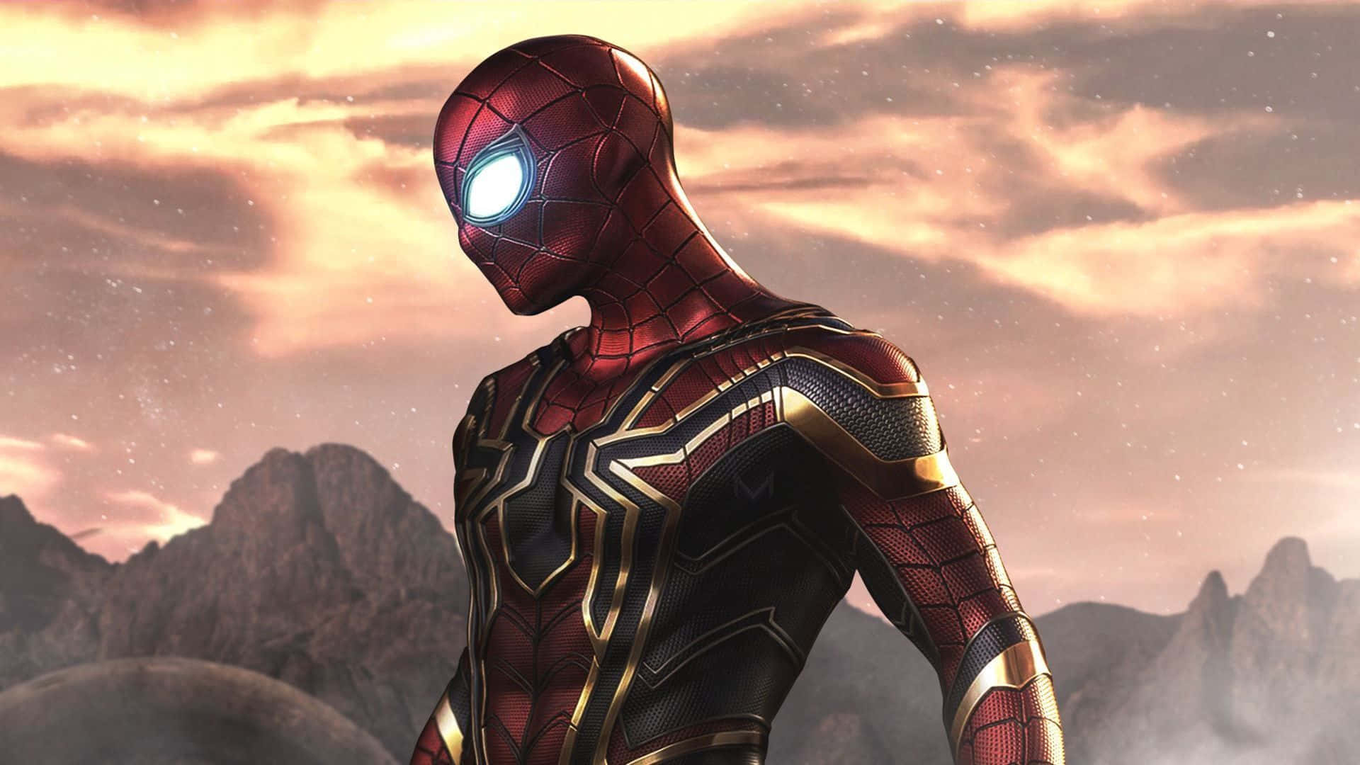 Best Marvel 桌布 壁紙 — 蜘蛛人穿著紅金色戰衣，英雄式地站在戲劇性的山脈日落天空前。