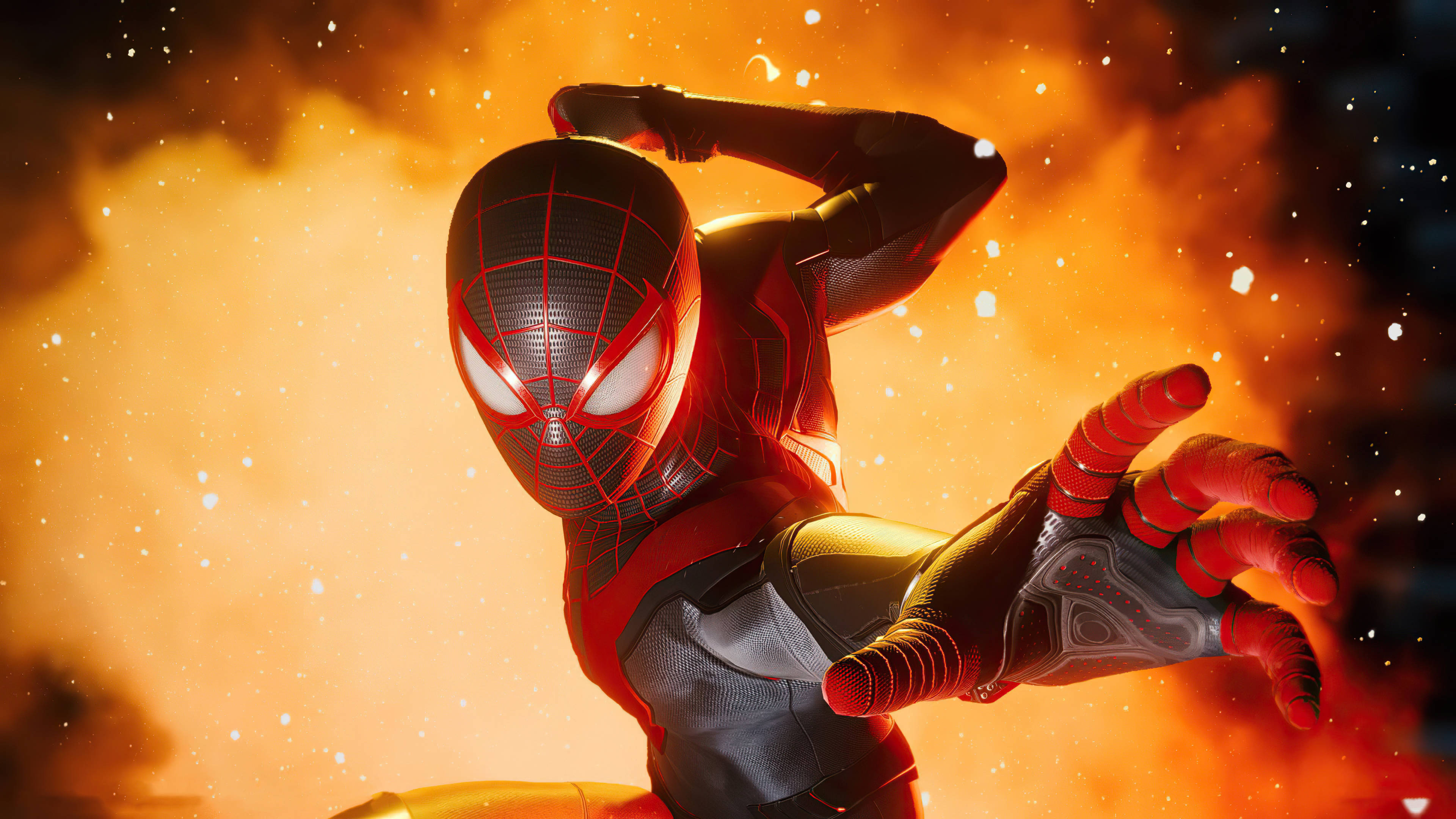Spider Man Miles Morales Ps5 桌布 壁紙 — 蜘蛛人穿著紅黑戰衣，在熾熱的橙色煙霧中動感擺姿勢，雙眼發光。