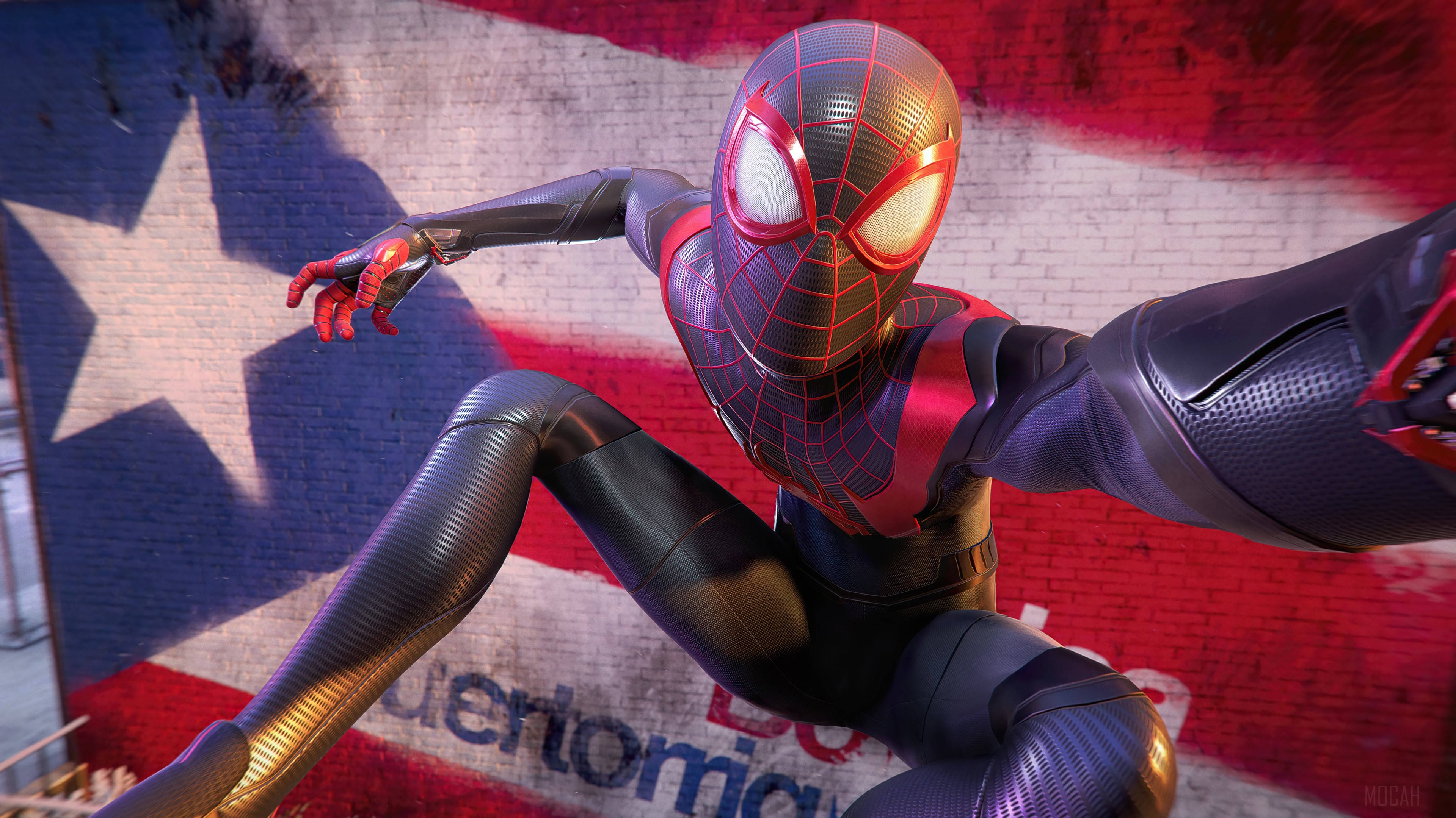 Spider Man Miles Morales Ps5 桌布 壁紙 — 蜘蛛人穿著紅黑色戰衣，動態地蹲在一幅塗滿美國國旗顏色塗鴉的磚牆前。