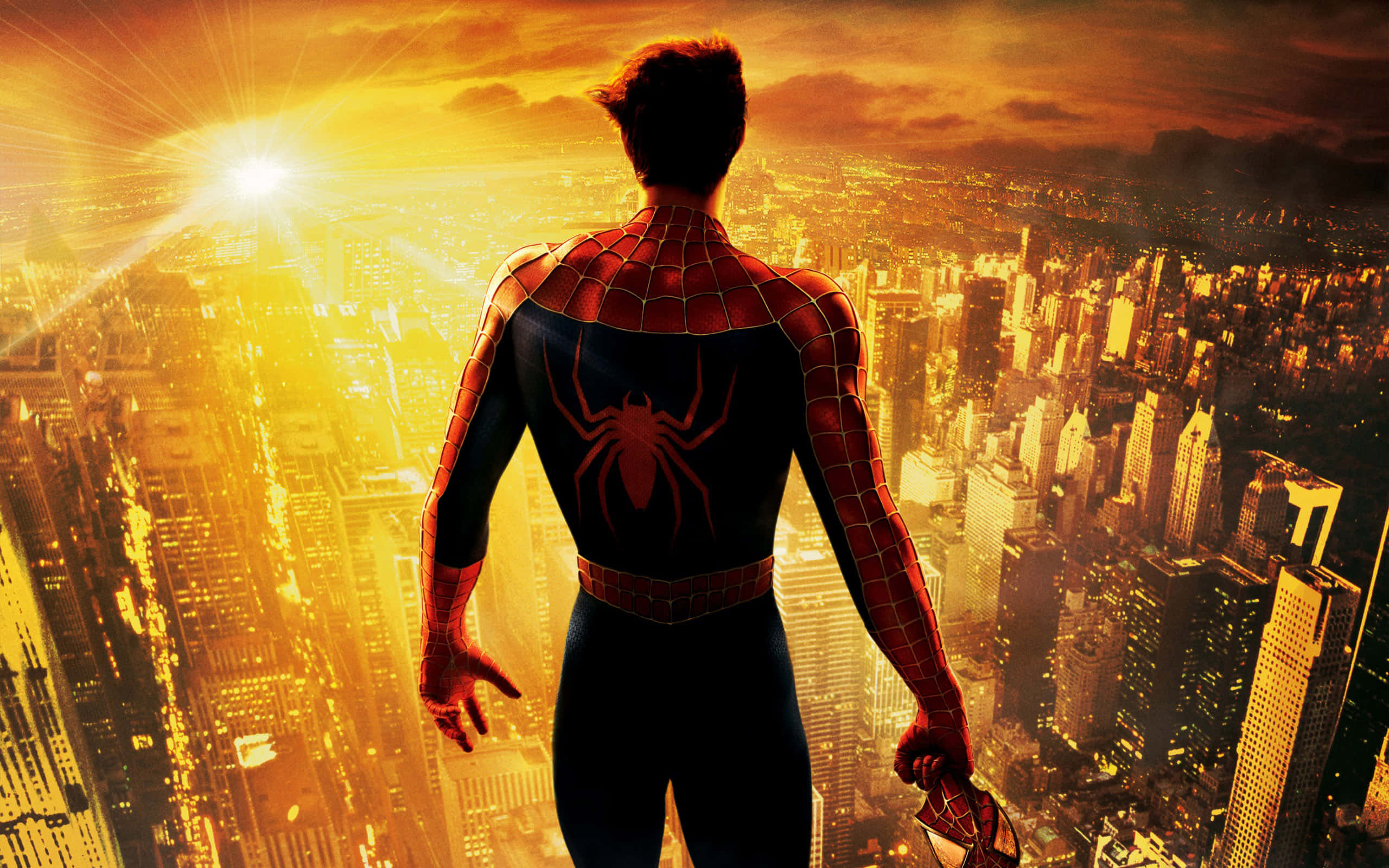 Spiderman Face 桌布 壁紙 — 蜘蛛人站在摩天大樓頂端，俯瞰夕陽下金光閃耀的城市天際線與燦爛的太陽光芒。