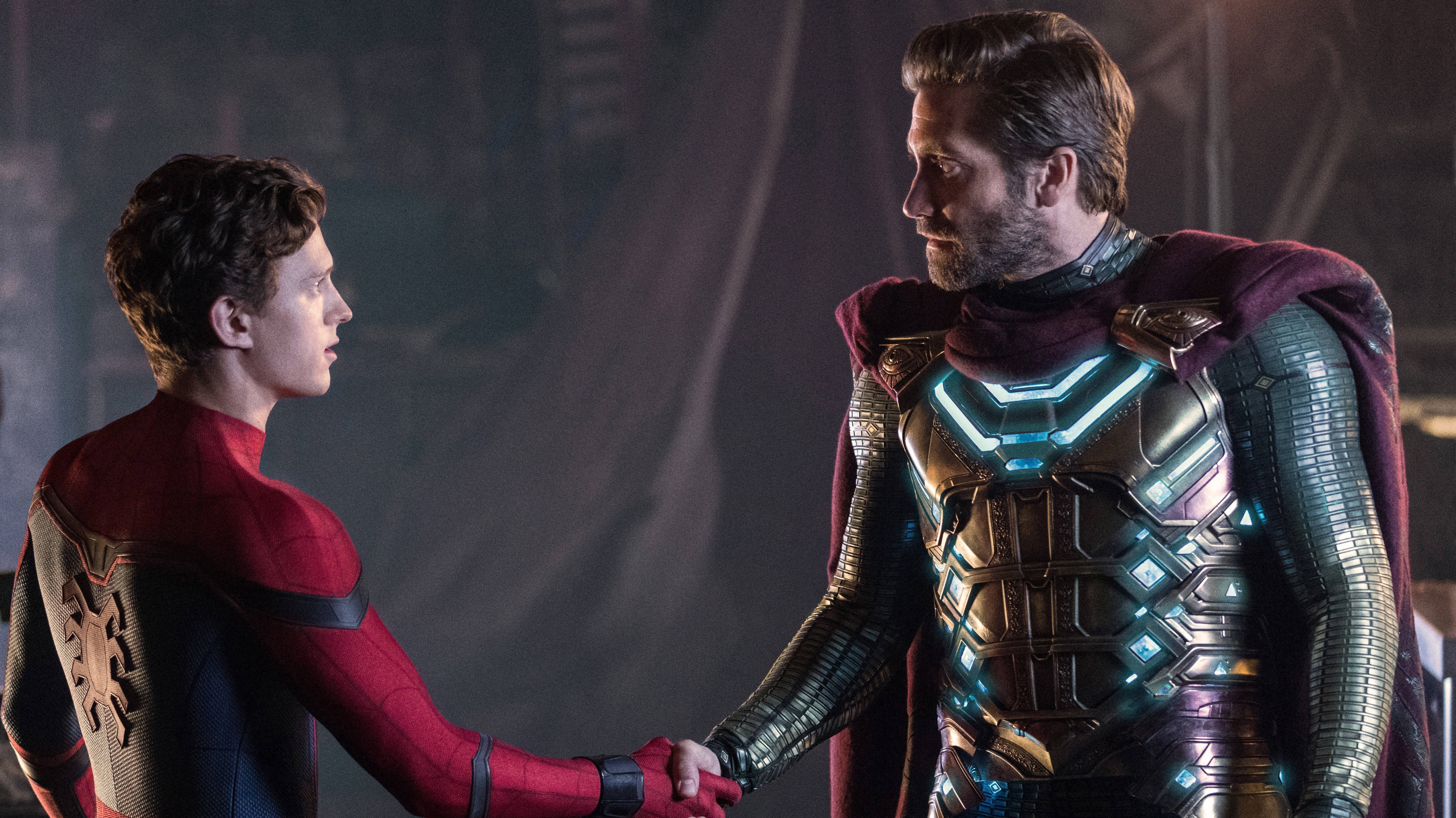 Mysterio 桌布 壁紙 — 蜘蛛人與神秘客在一個燈光昏暗、煙霧瀰漫的未來風格房間中握手，周圍有發光盔甲和戲劇性燈光。