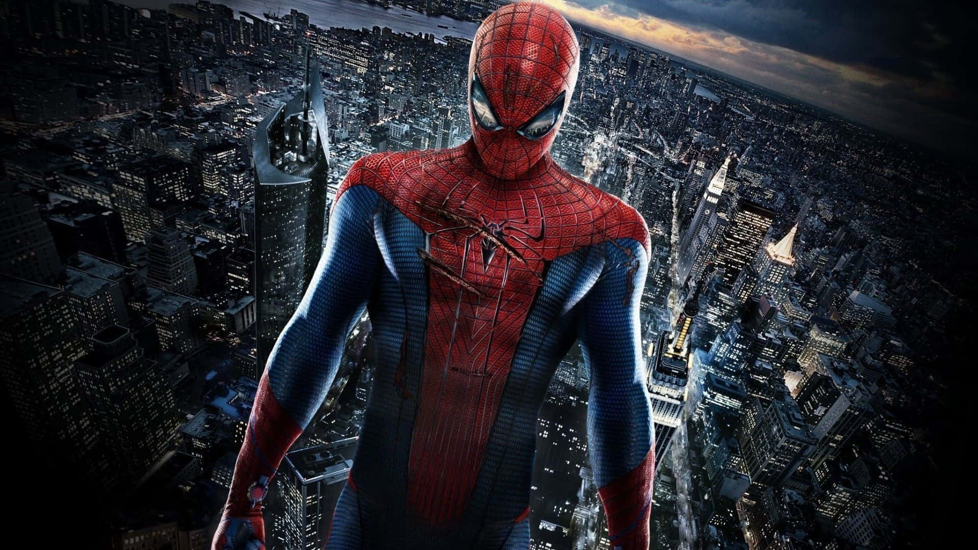 Best Spider Man 桌布 壁紙 — 蜘蛛人英雄式地站在摩天大樓頂端，俯瞰著暮色中窗戶閃爍的廣闊城市景觀。