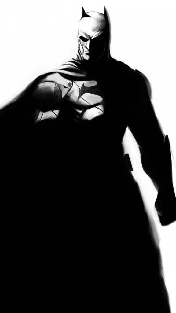 蝙蝠俠 iPhone 桌布 壁紙 — 蝙蝠俠以鮮明的黑白剪影站立，戲劇性的燈光突顯他的裝甲服和披風。