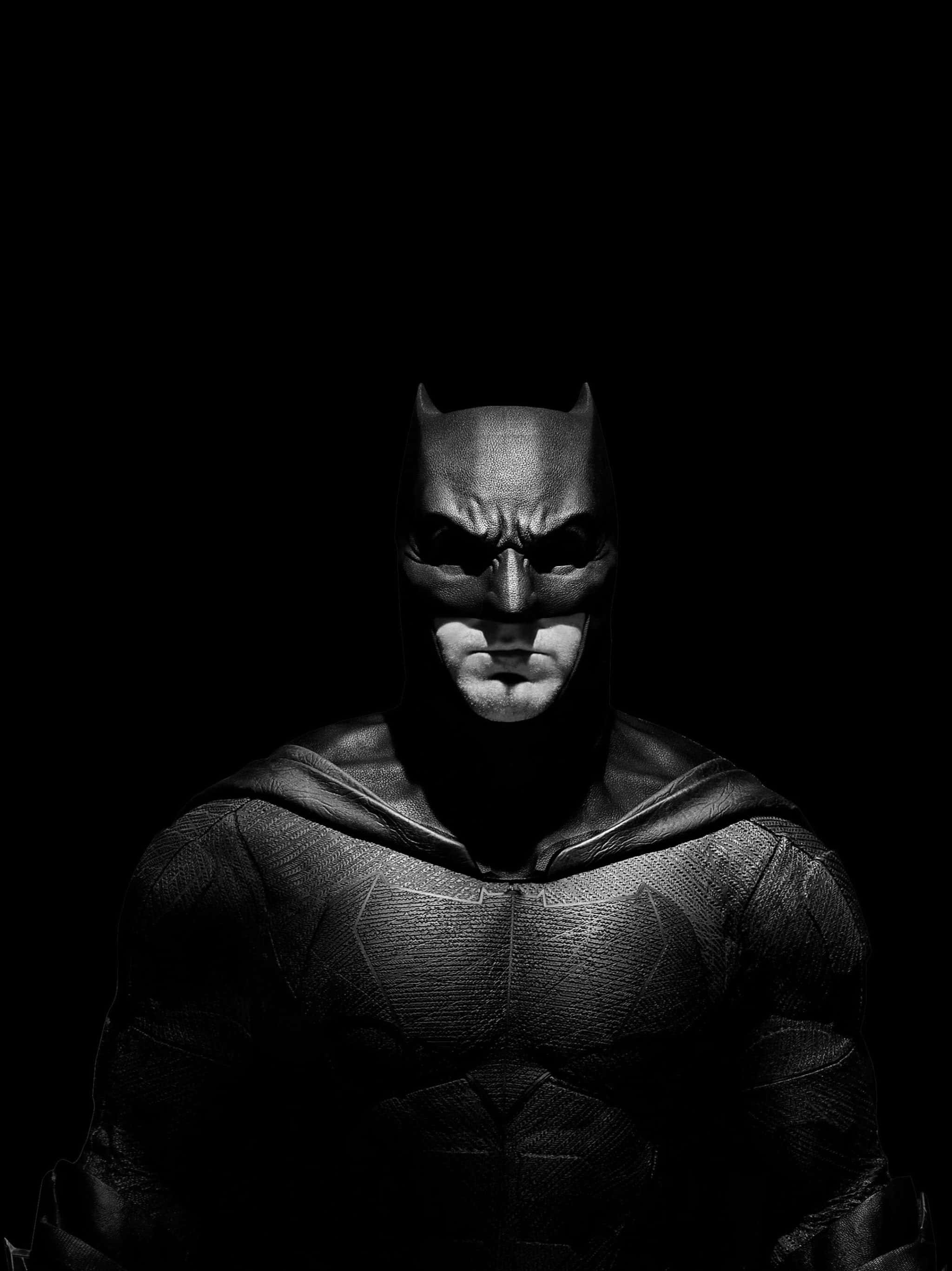 Batman Black And White 桌布 壁紙 — 蝙蝠俠以鮮明的黑白呈現，戲劇性的燈光突顯他強烈的表情和質感套裝，背景是虛無。