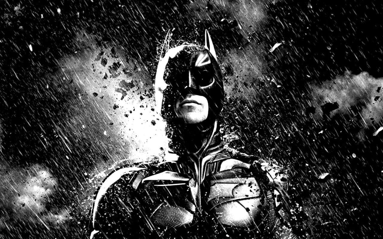 Batman The Dark Knight Returns 桌布 壁紙 — 蝙蝠俠在單色風暴中堅定站立，雨水和碎片圍繞著他的裝甲剪影旋轉。