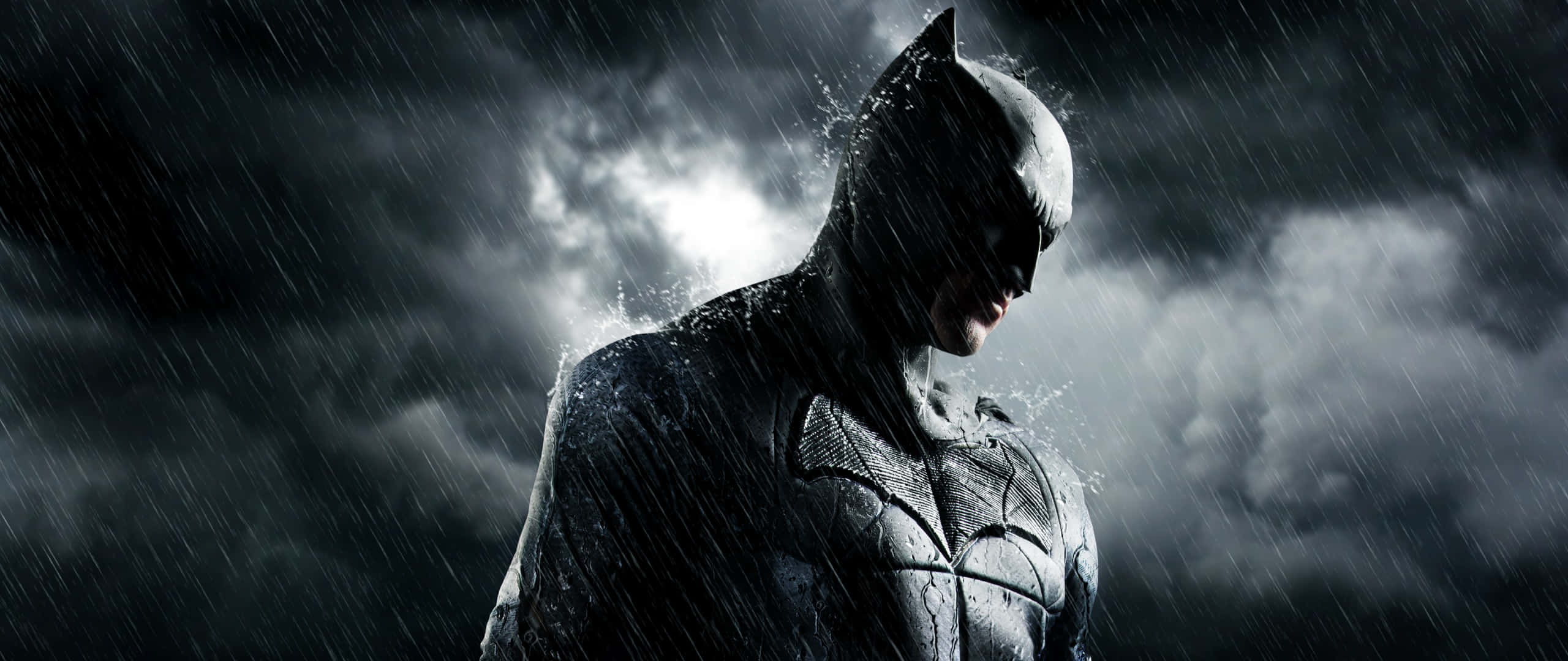 Bruce Wayne 桌布 壁紙 — 蝙蝠俠在暴風雨的天空下，雨水劃過他的裝甲戰衣，莊嚴地站立。