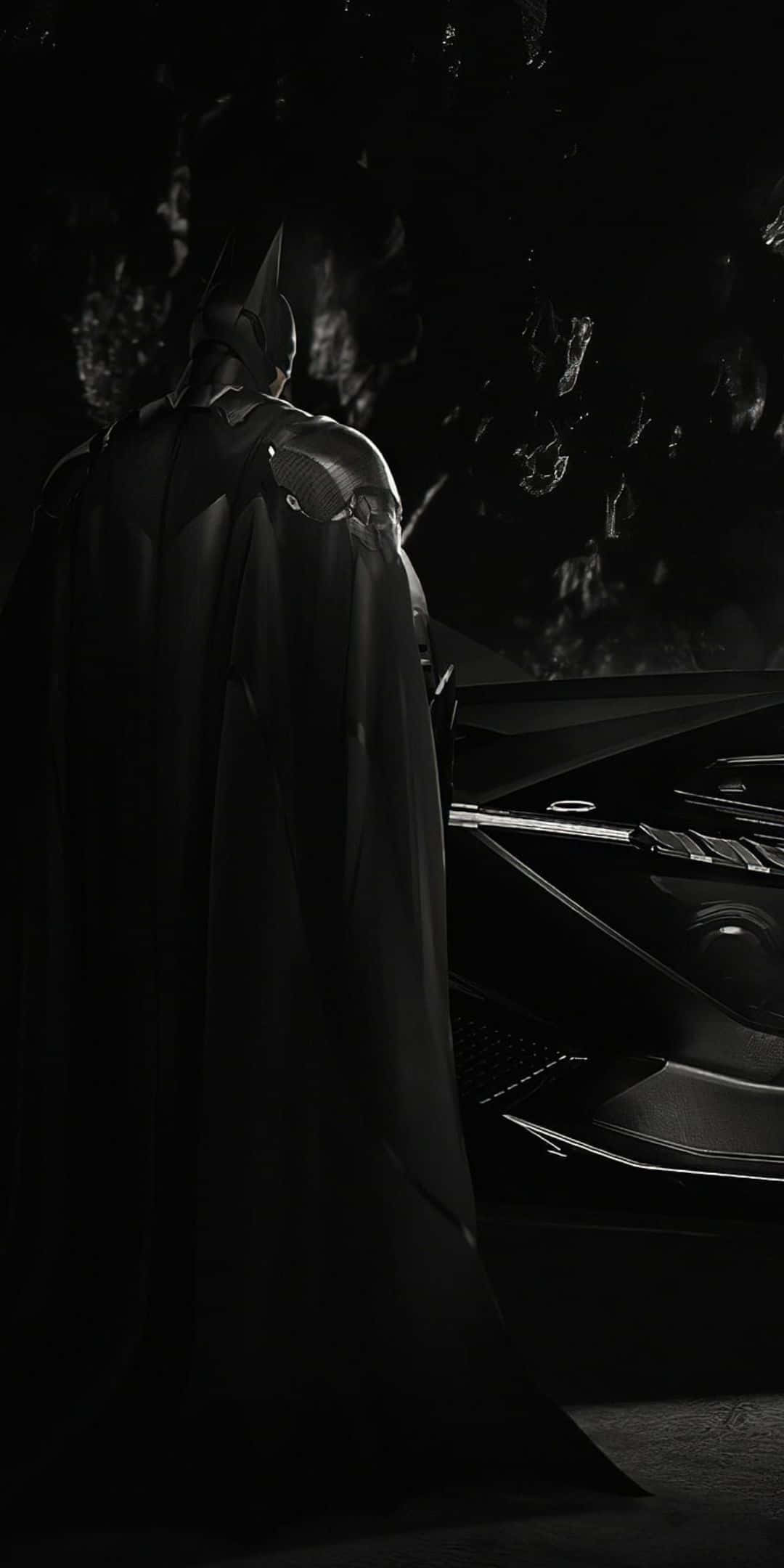 Pixel 3 Batmobile 桌布 壁紙 — 蝙蝠俠在月光下的黑暗洞穴中，站在他時尚的蝙蝠車旁邊的陰影中。
