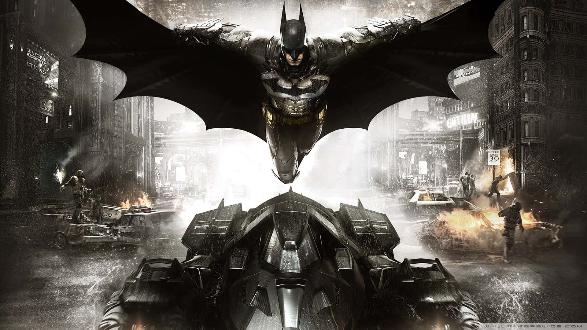 Batmobile Desktop 桌布 壁紙 — 蝙蝠俠在濕滑的高譚市街道上空翱翔，他的裝甲蝙蝠車在混亂與火焰中疾馳。