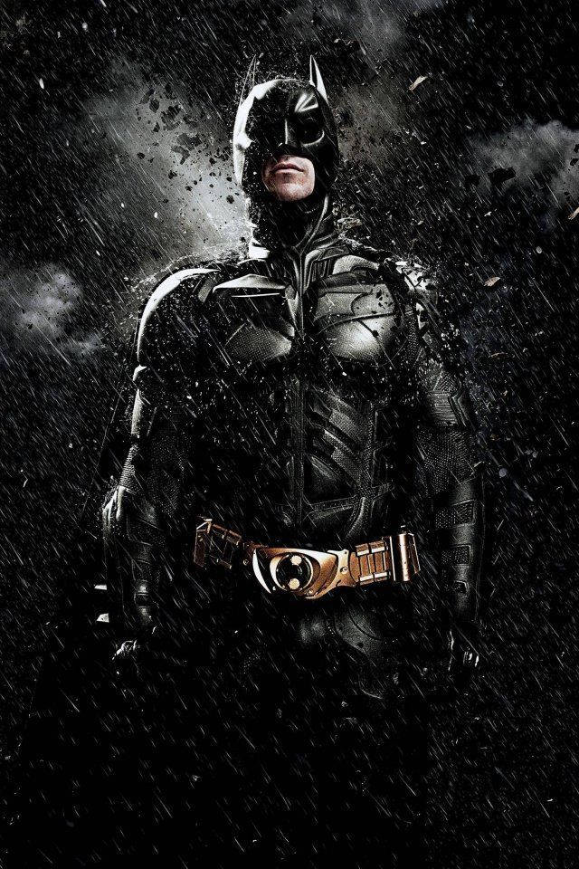 batman arkham city iPhone 桌布 壁紙 — 蝙蝠俠在雨中的高譚之夜堅定站立，他的裝甲服在戲劇性燈光下閃閃發光，碎片在他周圍飛舞。