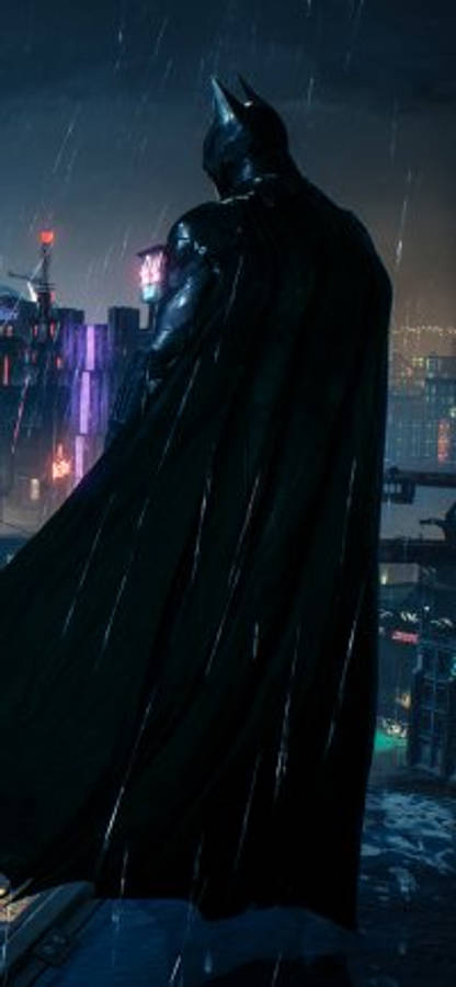 batman arkham city iPhone 桌布 壁紙 — 蝙蝠俠在雨中站在屋頂上，俯瞰著夜晚霓虹燈閃爍的高譚市景觀。