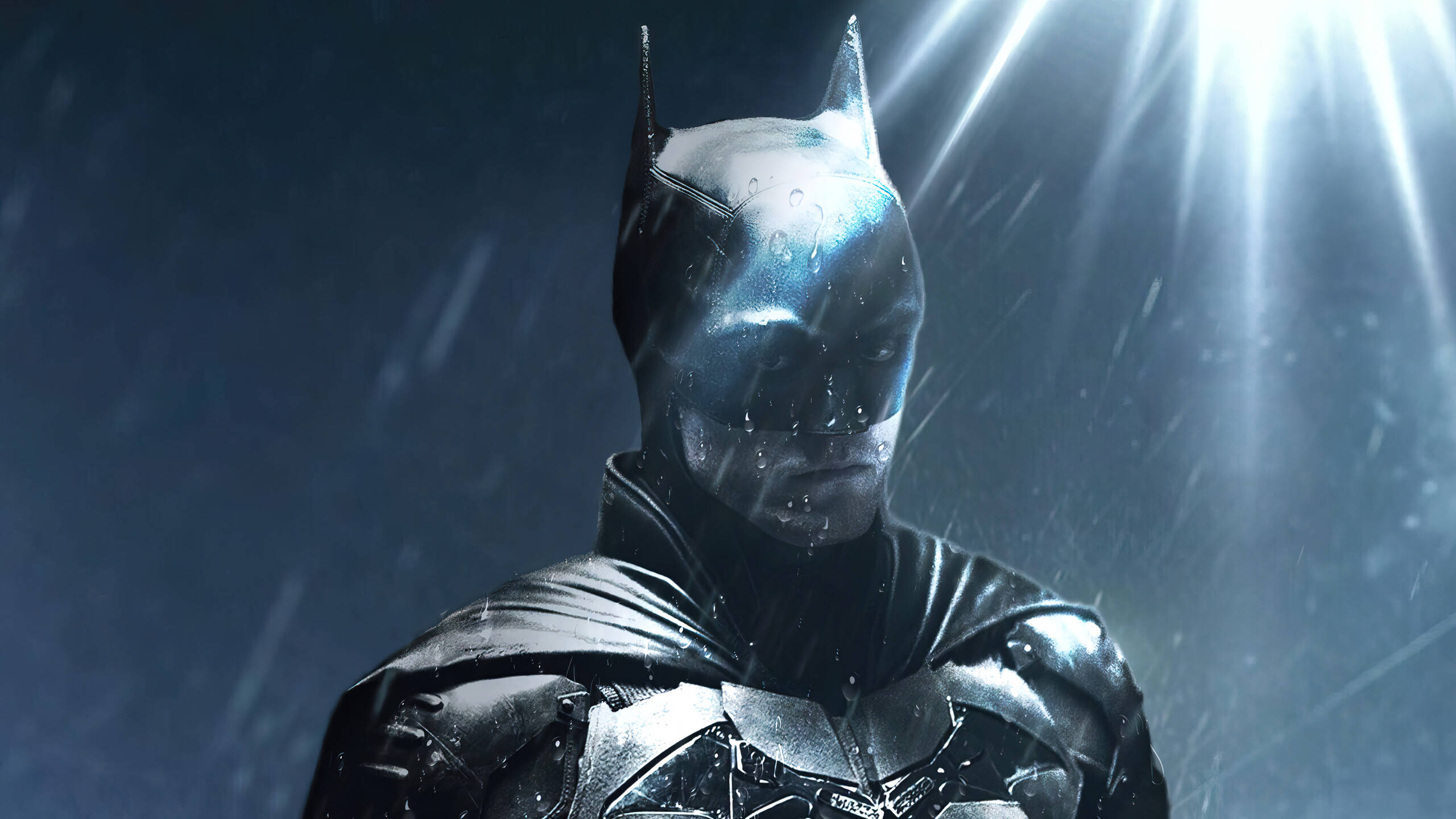 The Batman 桌布 壁紙 — 蝙蝠俠在雨夜中堅定站立，被刺穿暴風雨天空的戲劇性背光射線照亮。