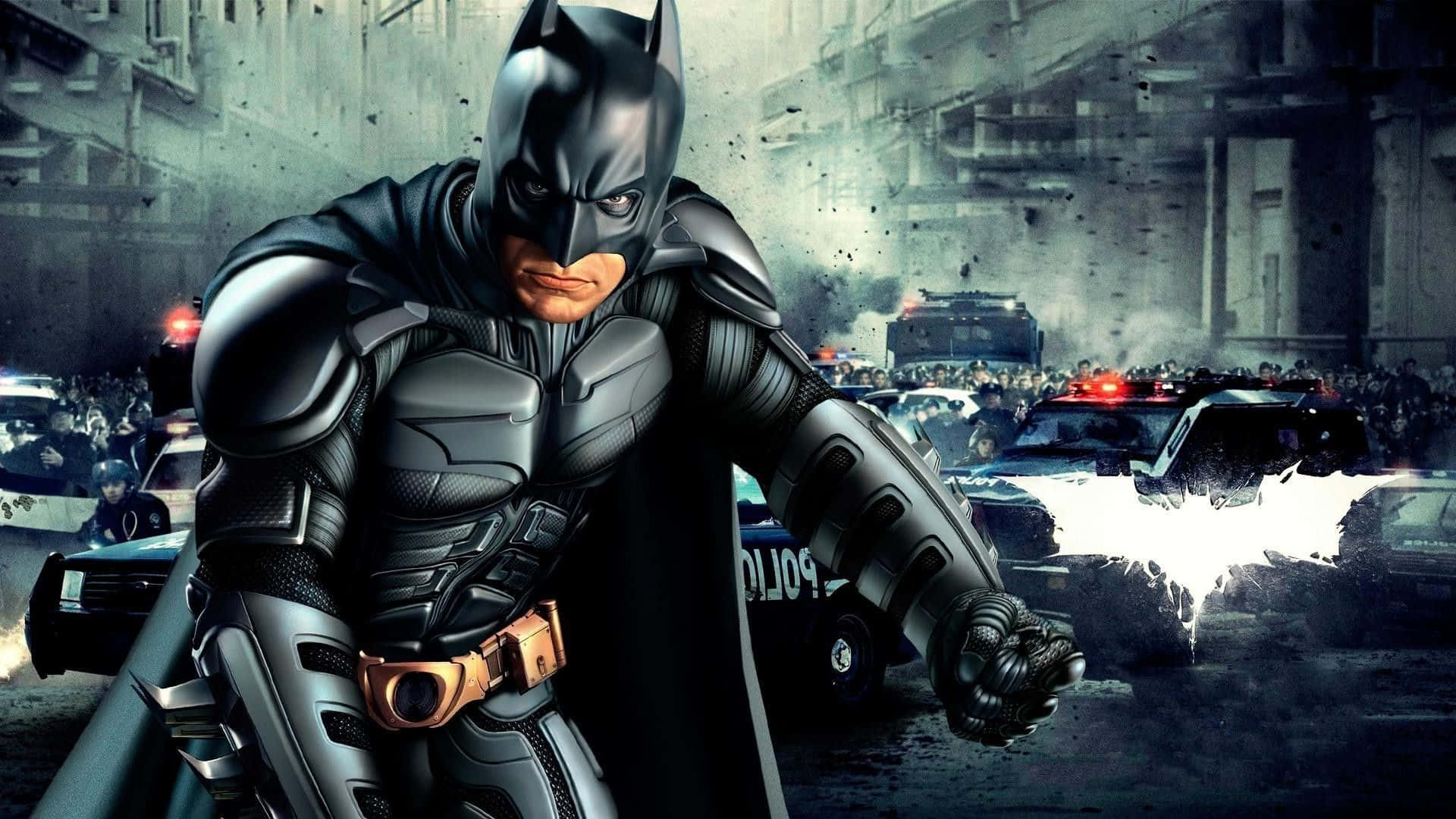 Batman Desktop 桌布 壁紙 — 蝙蝠俠在雨濕的高譚市街道上挑釁地站立，警車和人群在他身後混亂地湧動。