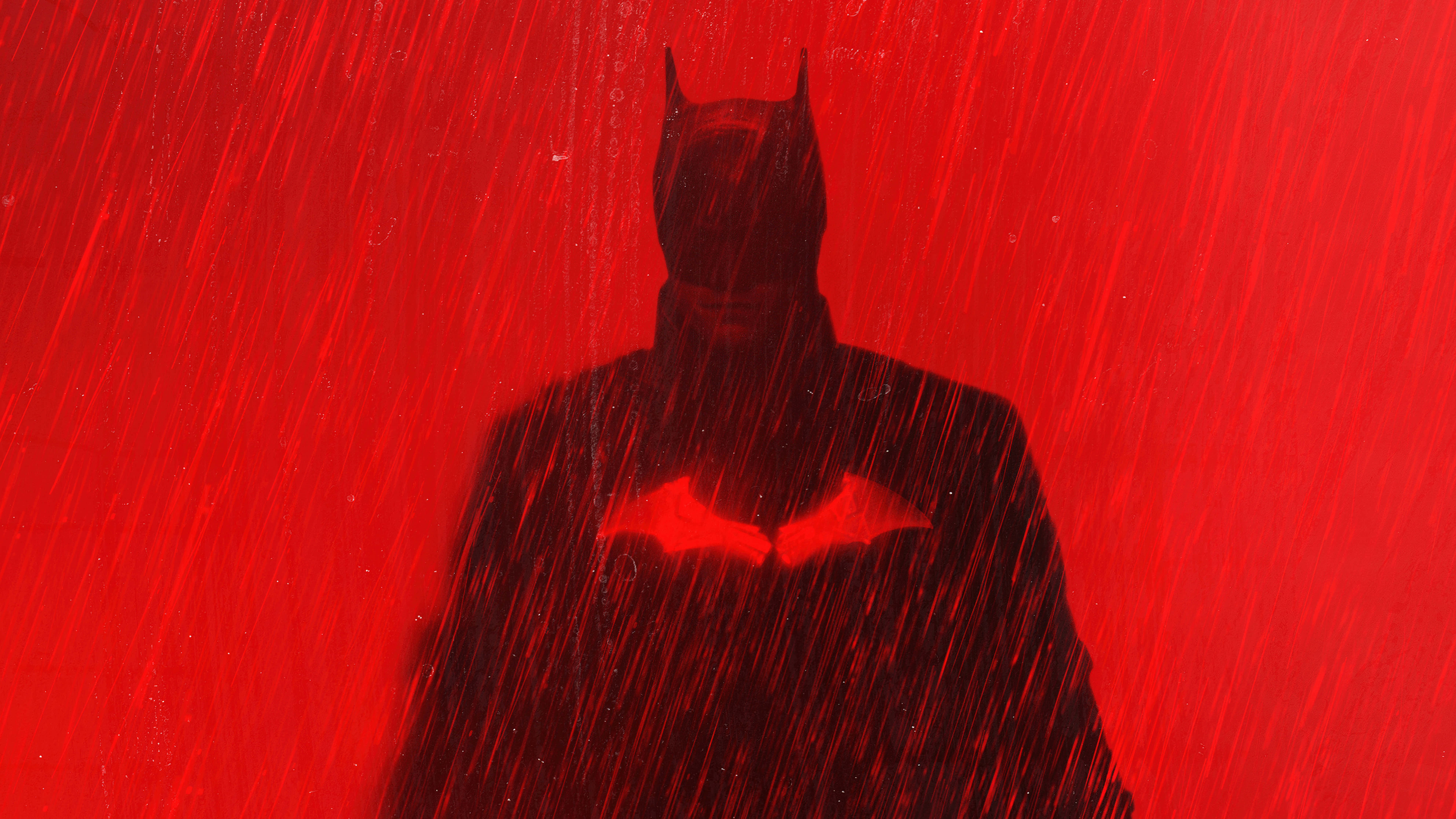 桌布 壁紙 — 蝙蝠俠在鮮紅色的暴雨中站立，呈現剪影，帶有發光的蝙蝠標誌。