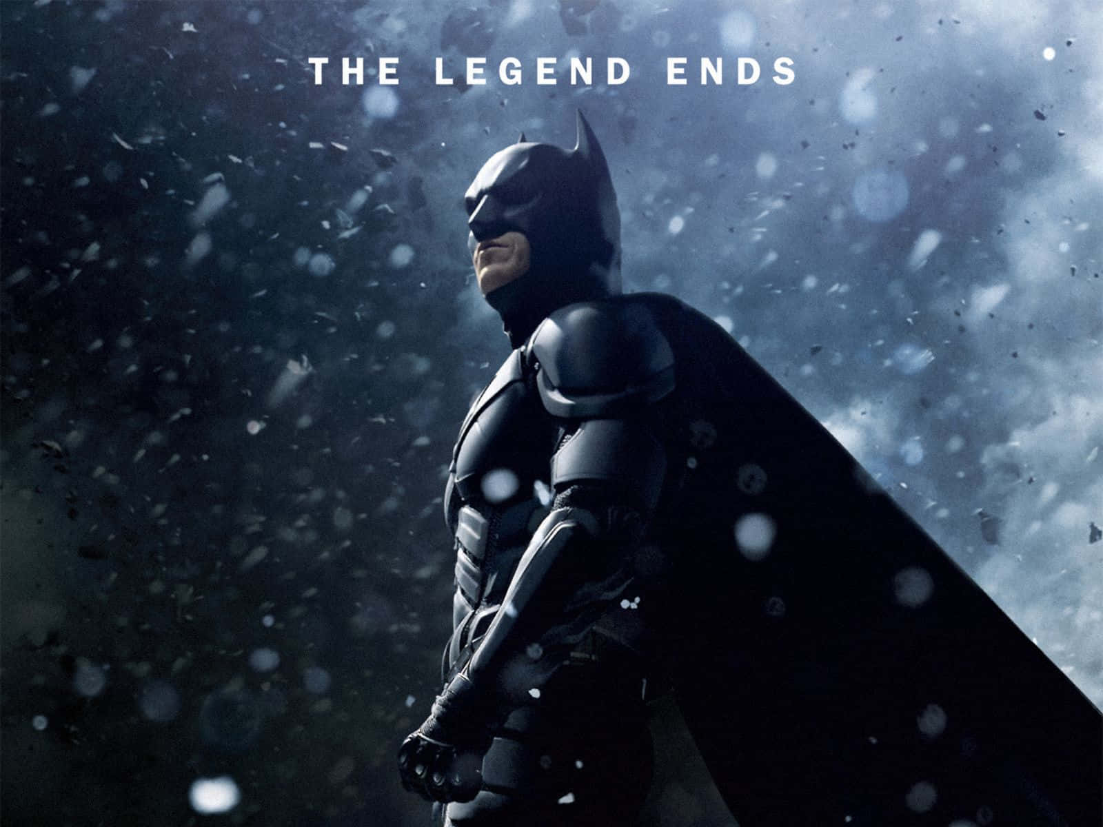 Batman The Dark Knight Returns 桌布 壁紙 — 蝙蝠俠在黑暗的天空下，莊嚴地站在暴風雪中，雪花在他周圍飄舞。