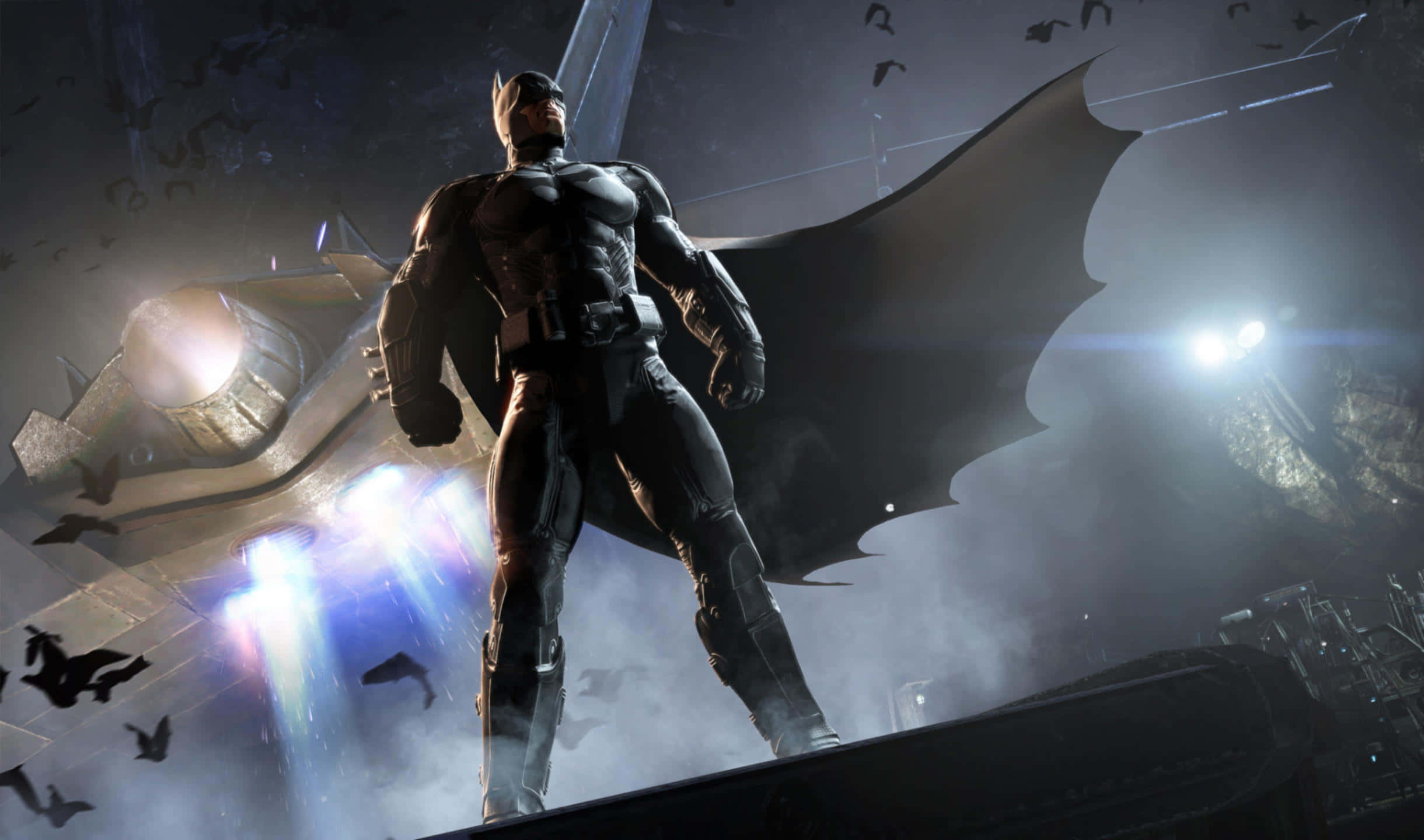 2440x1440 Batman Arkham City 桌布 壁紙 — 蝙蝠俠夜晚站在屋頂上，披風飄揚，蝙蝠在他周圍飛翔，身後有一輛發光的蝙蝠車。