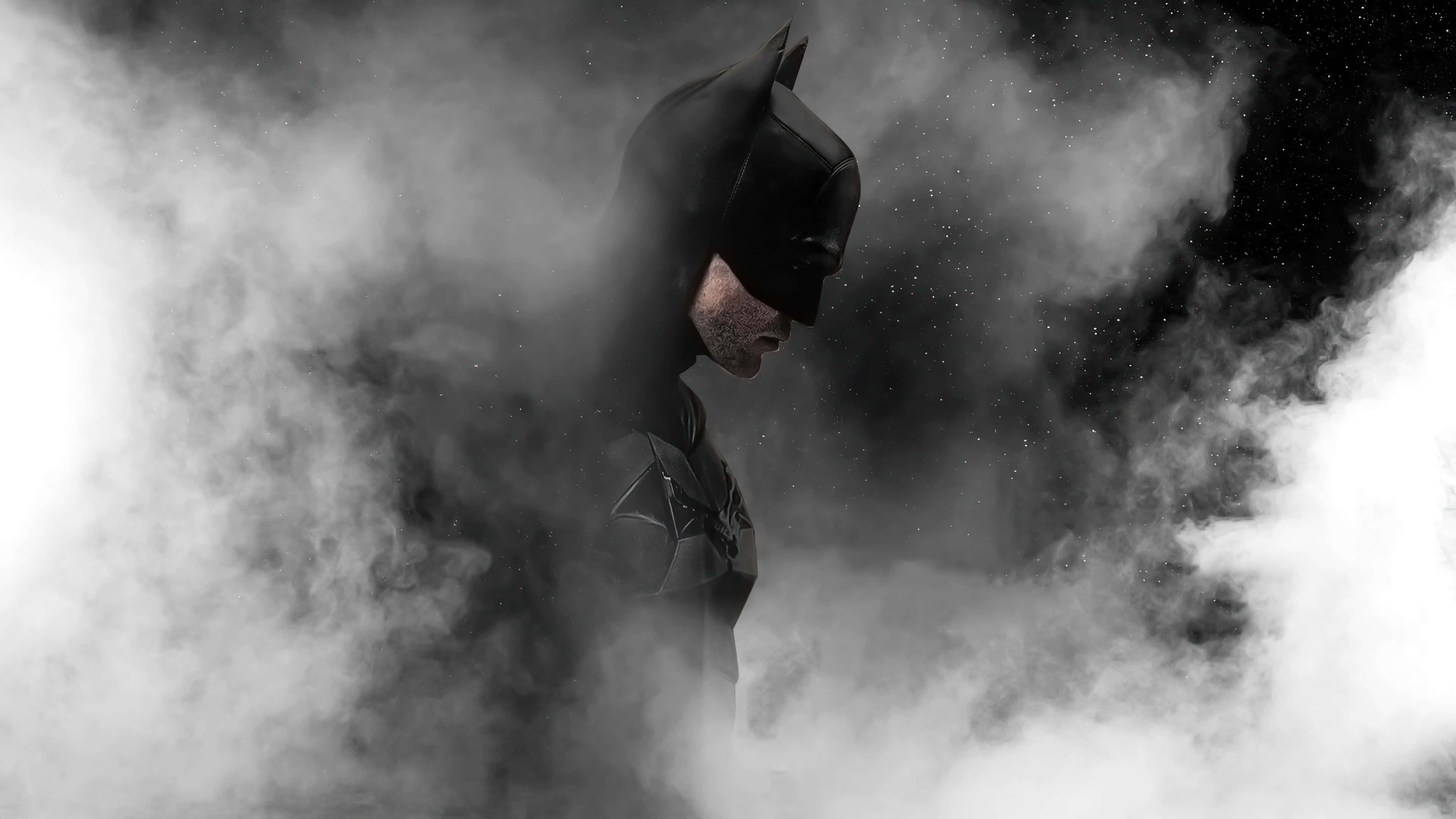 The Batman 桌布 壁紙 — 蝙蝠俠從旋轉的煙霧中出現，在一個帶有戲劇性燈光的鮮明黑白場景中。