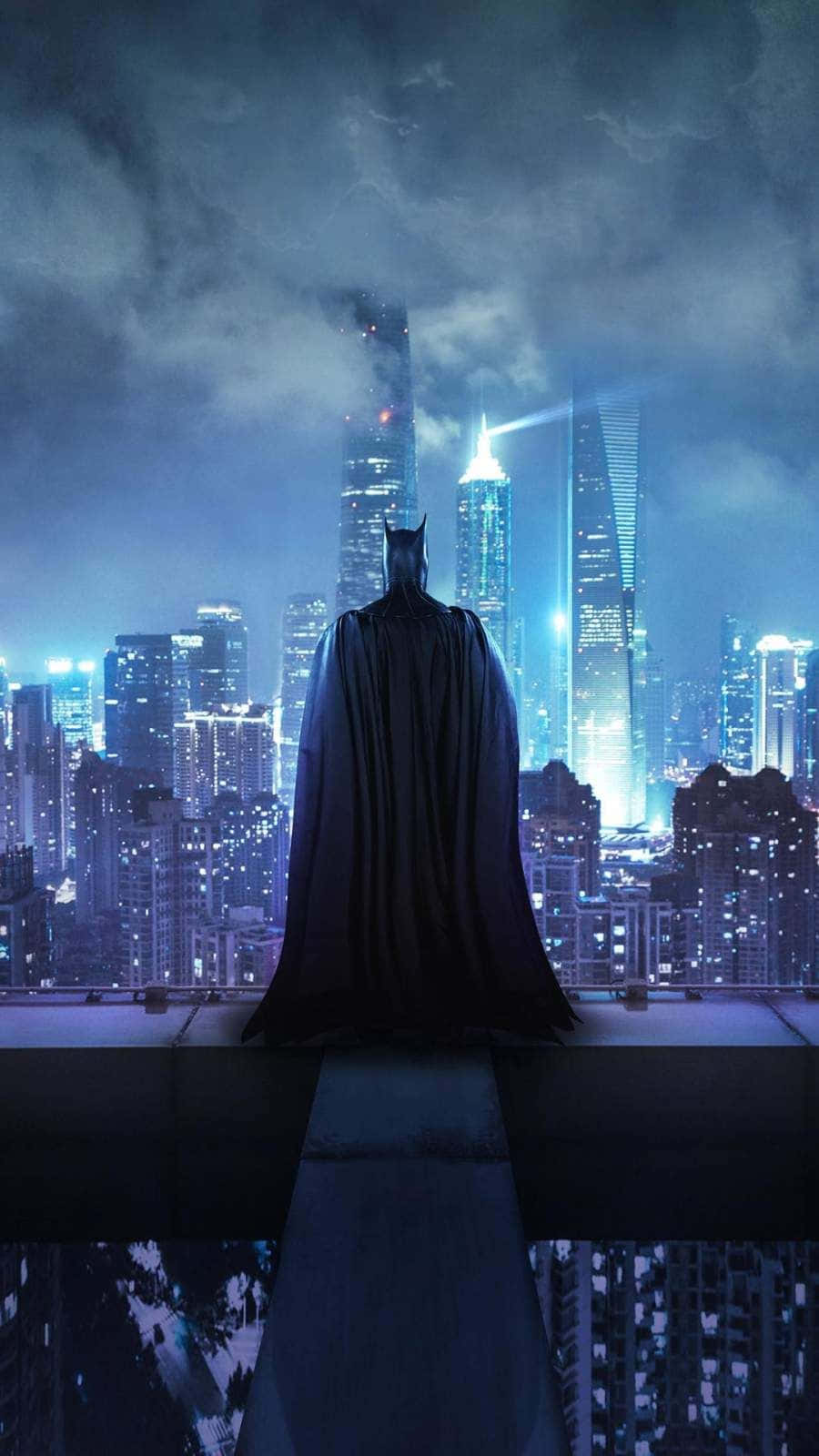 Batman The New 52 桌布 壁紙 — 蝙蝠俠獨自站在屋頂上，俯瞰著暴風雨夜空下霓虹燈閃爍的高譚市天際線。