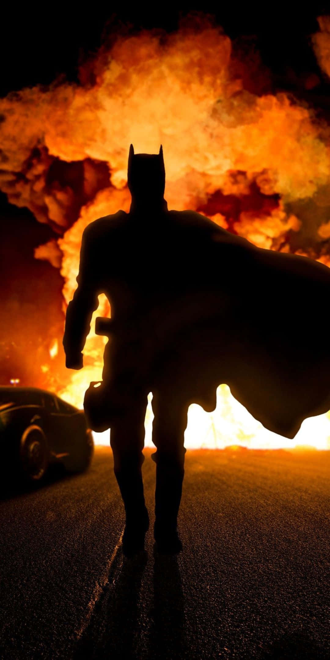 Pixel 3 Batmobile 桌布 壁紙 — 蝙蝠俠的剪影在照亮夜街的巨大火焰爆炸前傲然挺立。