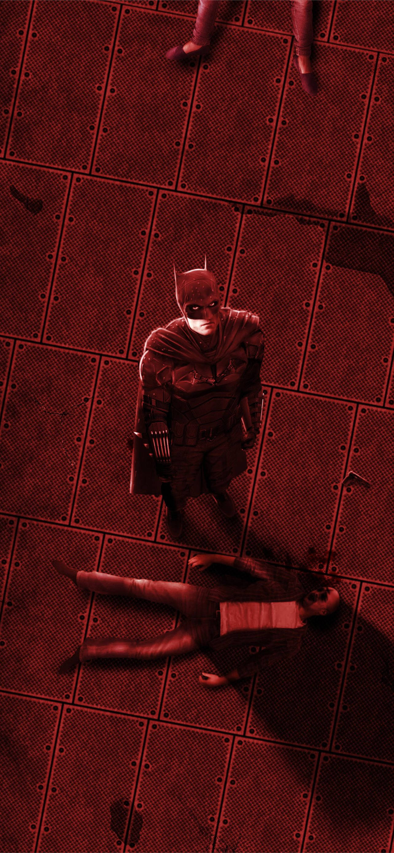 The Batman 桌布 壁紙 — 蝙蝠俠站在一個昏暗紅色燈光的工業房間裡，金屬地板上，站在一個倒下的人物上方。