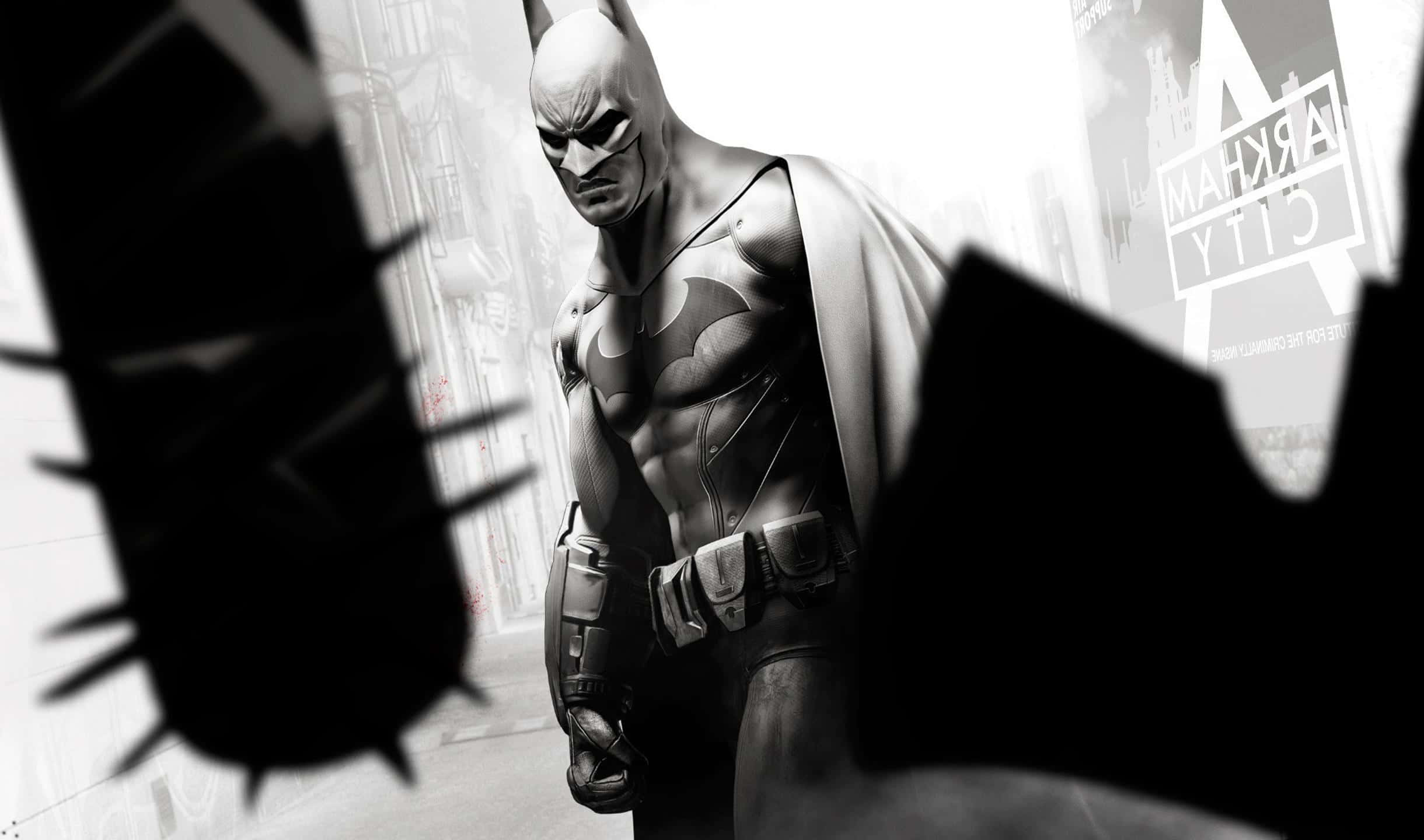2440x1440 Batman Arkham City 桌布 壁紙 — 蝙蝠俠站在一個陰暗的城市小巷中，周圍是破損建築的黑暗剪影，背景可見「阿卡姆城」。