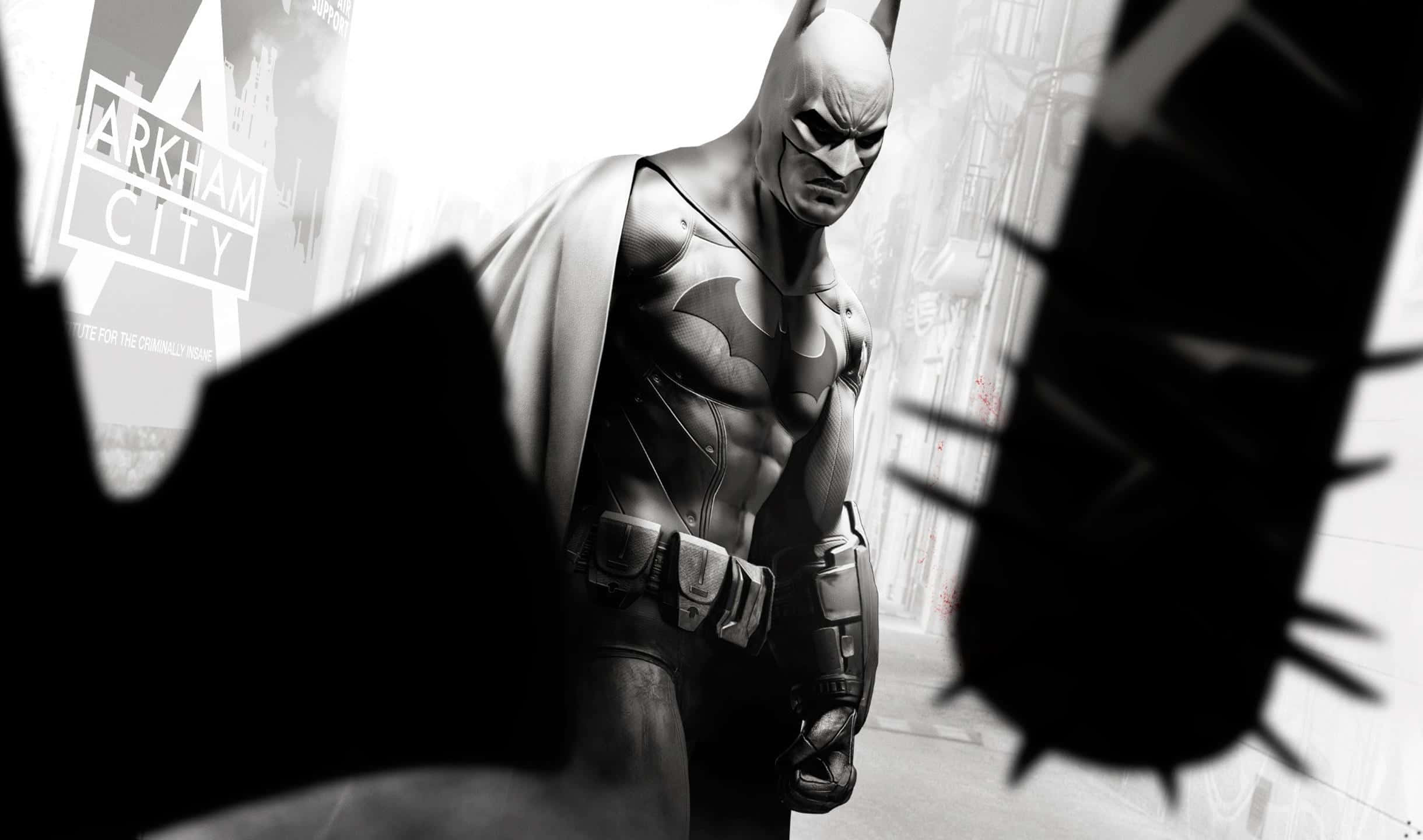 2440x1440 Batman Arkham City 桌布 壁紙 — 蝙蝠俠站在一個骯髒的城市小巷中，被黑暗的剪影框住，背景中可見「阿卡姆之城」的標誌。