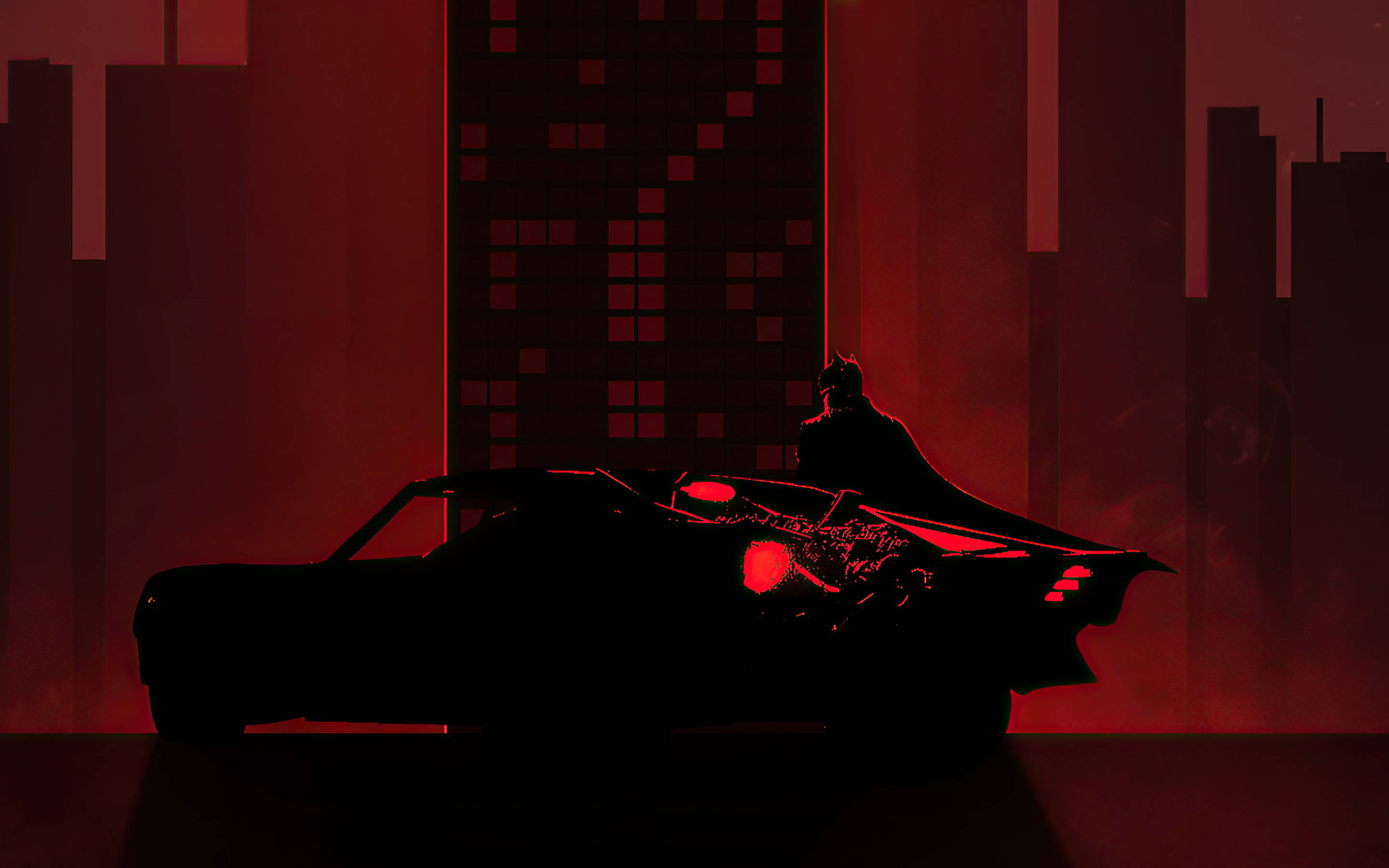 The Batman 桌布 壁紙 — 蝙蝠俠站在他的蝙蝠車上，背景是紅光籠罩的高譚市天際線，高樓大廈聳立。