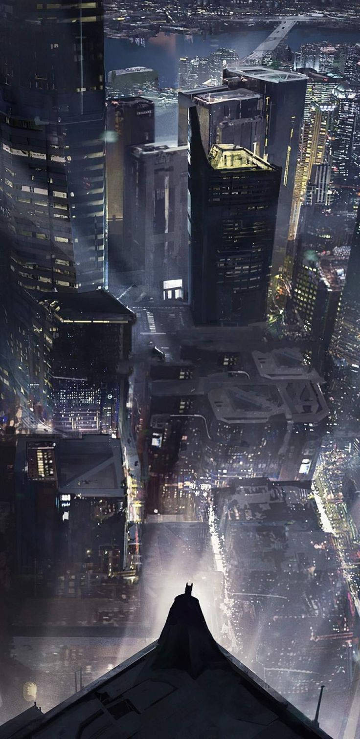 Arkham 桌布 壁紙 — 蝙蝠俠站在屋頂上，俯瞰著夜晚被雨水浸濕的霓虹城市景觀，下方高聳的摩天大樓閃閃發光。