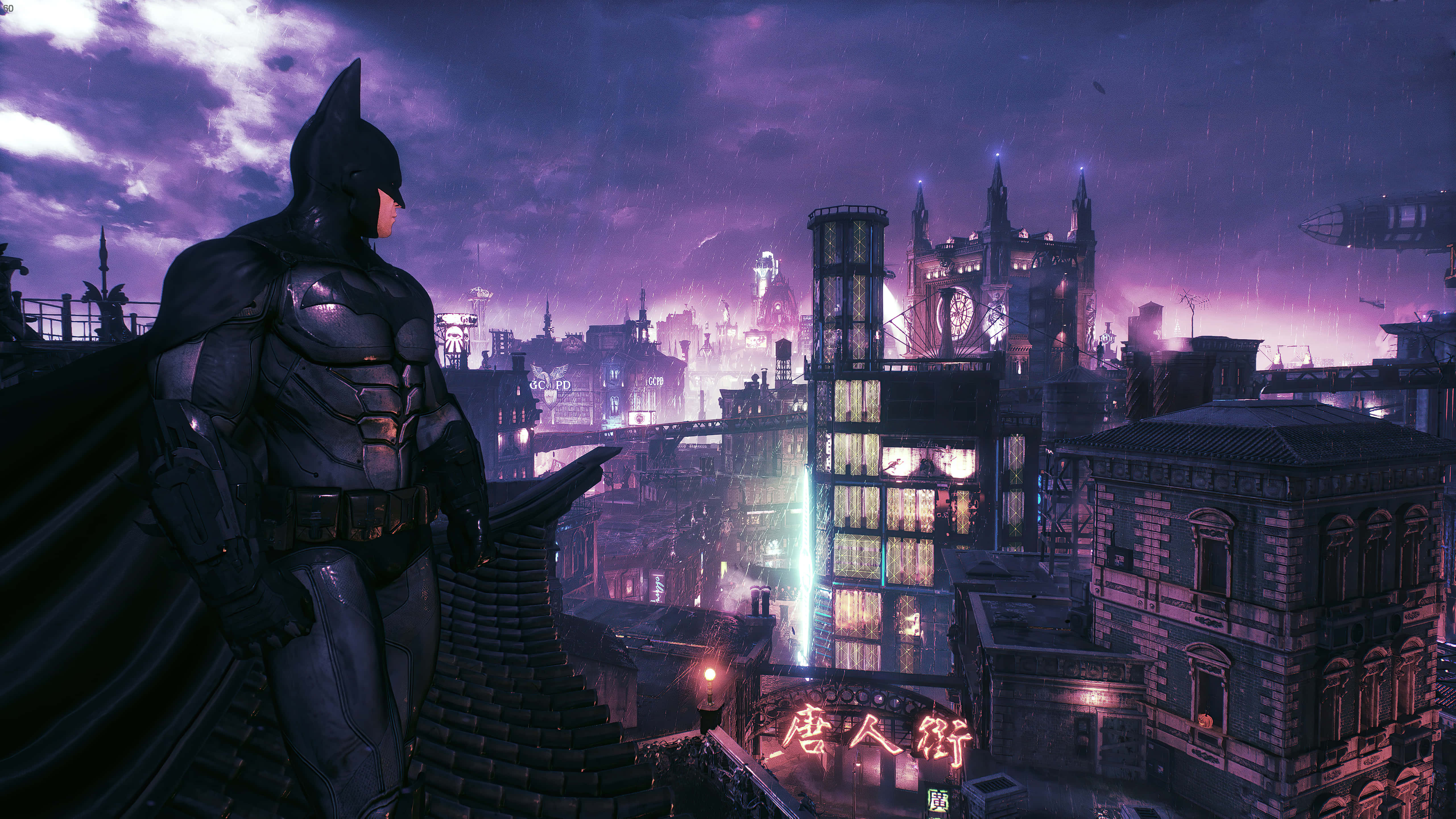 Batman City 桌布 壁紙 — 蝙蝠俠站在屋頂上，俯瞰著暮色中雨淋濕的哥譚市，霓虹燈光反射在濕漉漉的街道上。