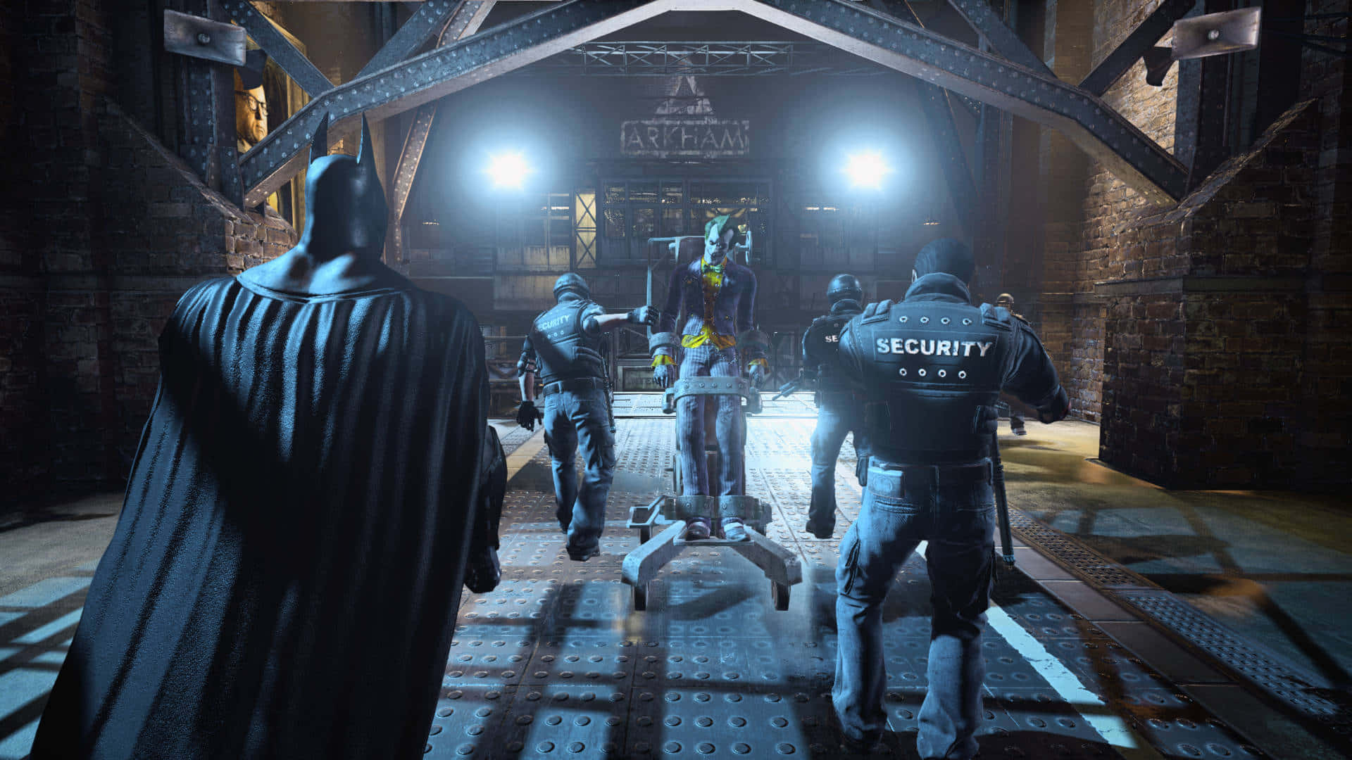 Arkham Asylum 桌布 壁紙 — 蝙蝠俠站在昏暗的工業大廳中，警衛在強烈聚光燈下護送被制伏的小丑走向阿卡姆標誌。