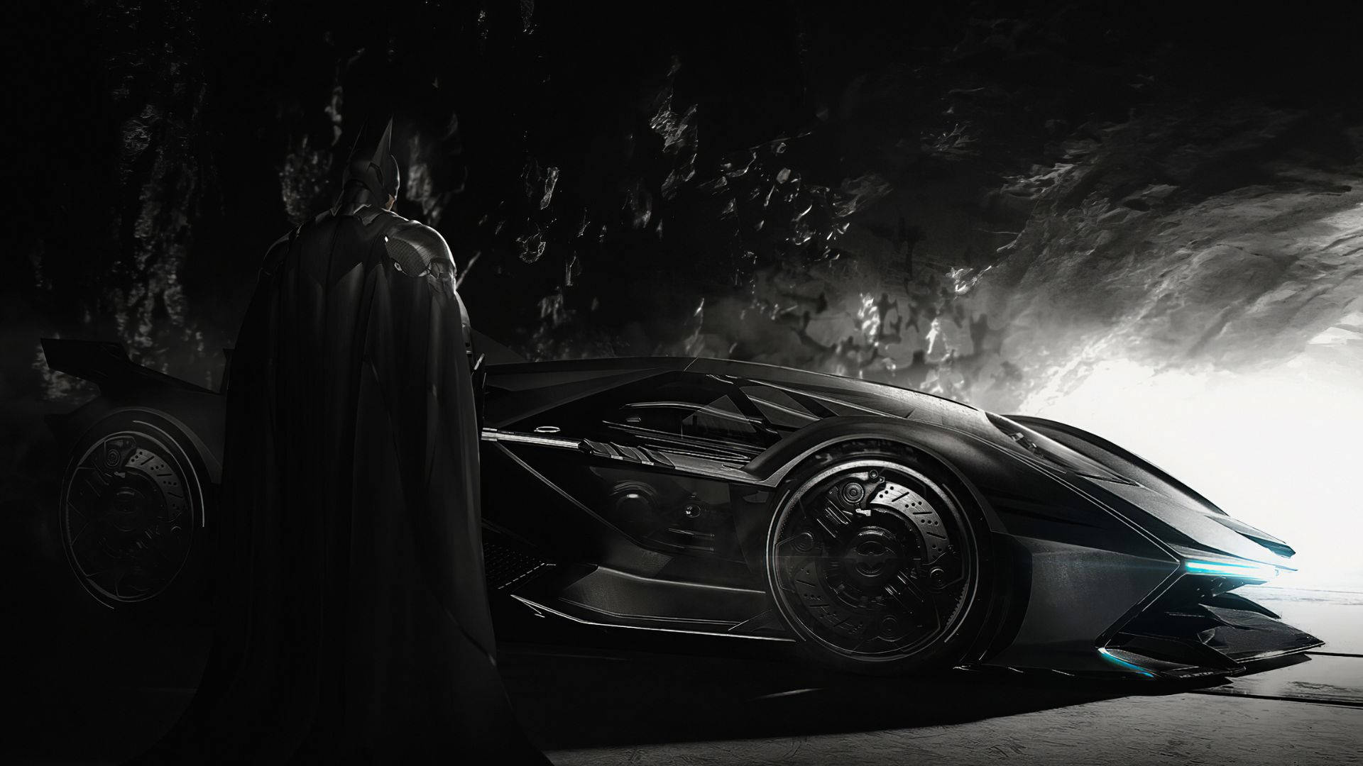 Batmobile 桌布 壁紙 — 蝙蝠俠站在陰影中，旁邊是他時尚的黑色蝙蝠車，在一個洞穴般的巢穴中，被戲劇性的背光照亮。