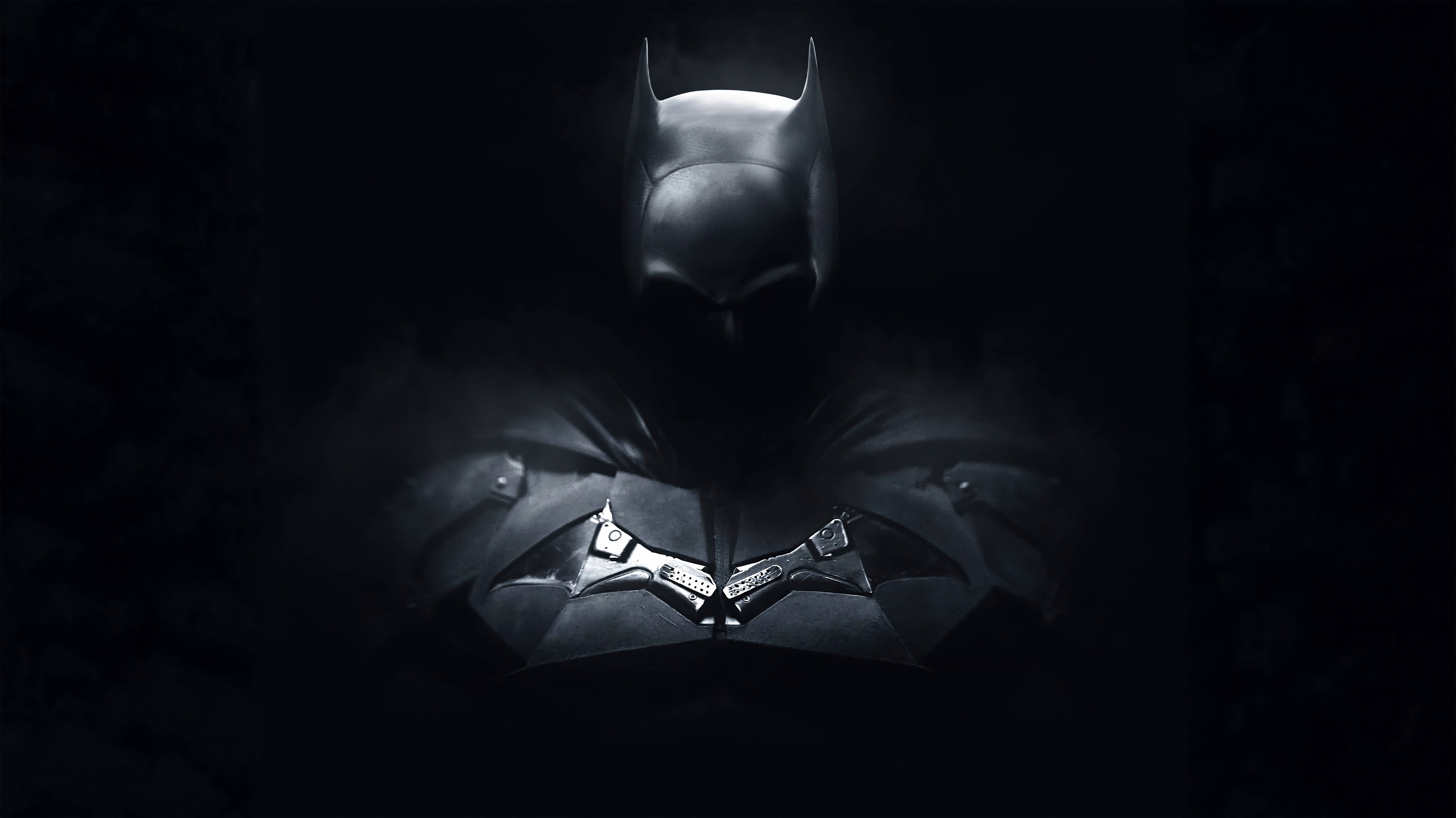 The Batman 桌布 壁紙 — 蝙蝠俠站在陰影黑暗中，其標誌性的頭罩和裝甲胸板被一道戲劇性的光線照亮。
