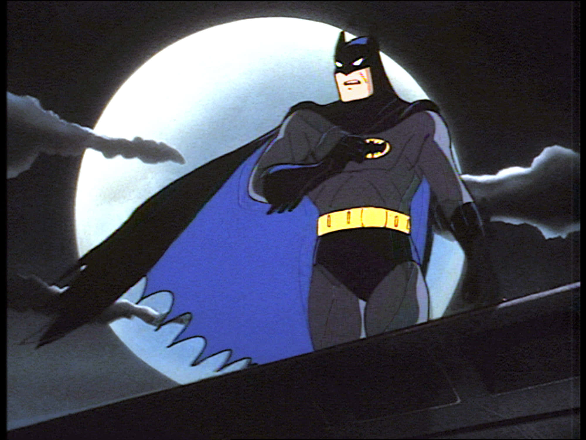 Batman Animated Adventures 桌布 壁紙 — 蝙蝠俠英雄地站在屋頂上，背景是滿月，戲劇性的雲朵在他周圍旋轉。