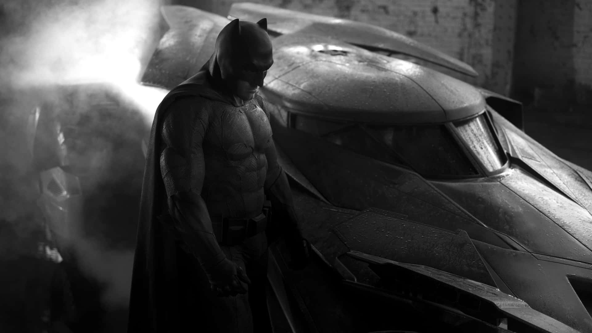 Bruce Wayne 桌布 壁紙 — 蝙蝠俠莊嚴地站在他的裝甲蝙蝠車旁，車庫煙霧瀰漫，燈光昏暗。