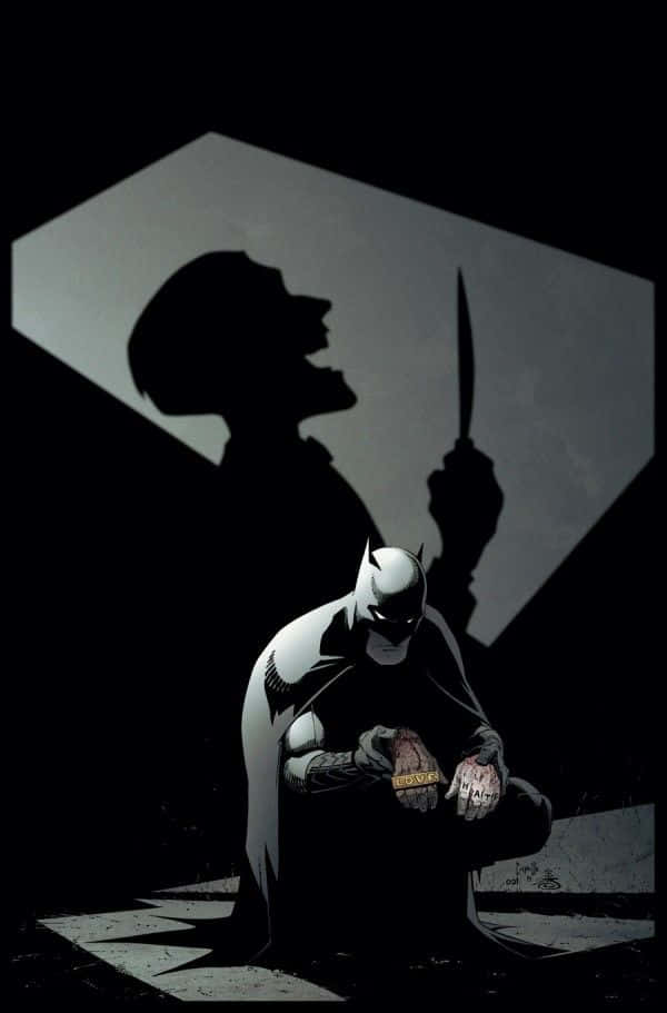 Batman Death In The Family 桌布 壁紙 — 蝙蝠俠跪在陰影中，一個手持刀子的威脅性剪影在他身後若隱若現。