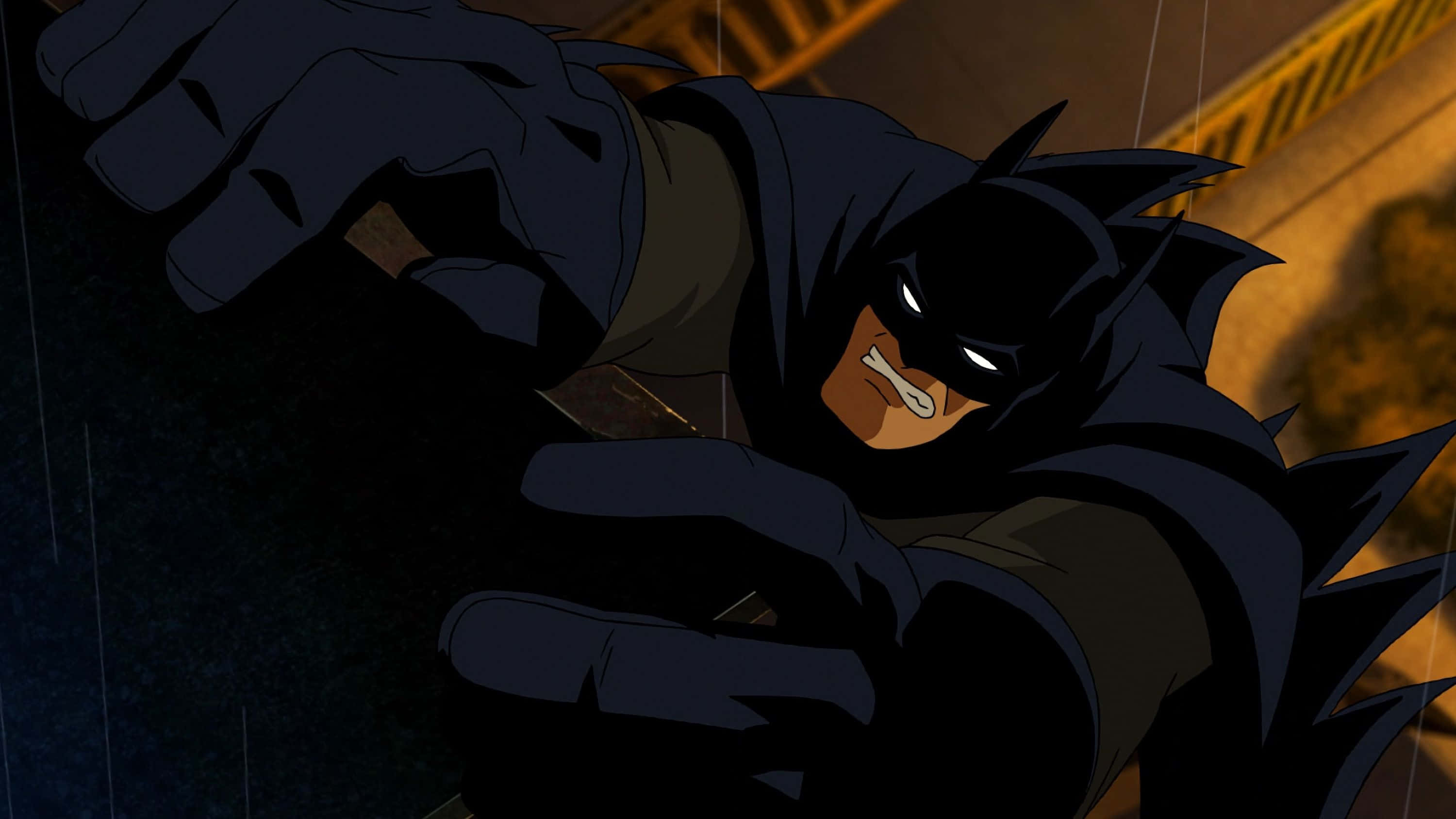 Batman Death In The Family 桌布 壁紙 — 蝙蝠俠蹲在雨濕的陰影中，雙眼發光，拳頭緊握，背景是 gritty 的城市景觀。