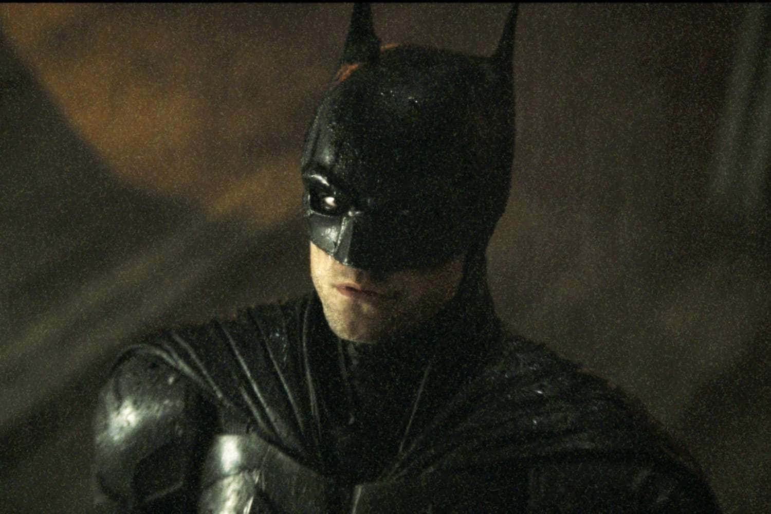 Bat-suit 桌布 壁紙 — 蝙蝠俠身穿深色濕透的雨衣，在昏暗的小巷中，帶有粗糙質感和氣氛燈光，專注地凝視。