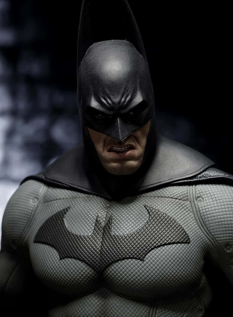 Arkham Asylum 桌布 壁紙 — 蝙蝠俠身穿質感裝甲服的近距離特寫，在黑暗模糊的背景中露出嚴峻的表情。