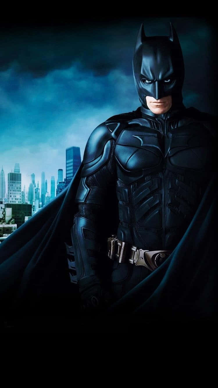 Batman Arkham Knight 桌布 壁紙 — 蝙蝠俠身穿黑色斗篷，在風雨交加的城市天際線前，立於陰鬱的藍天下。