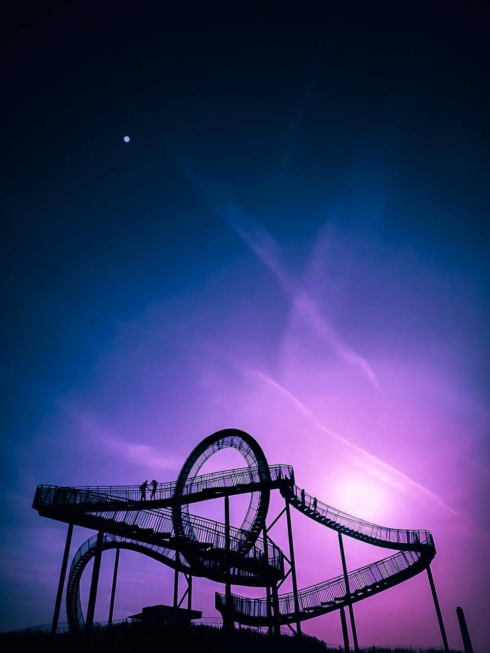 Roller Coaster 桌布 壁紙 — 螺旋形步道的剪影，映襯著充滿活力的紫色和藍色暮色天空，可見月亮。