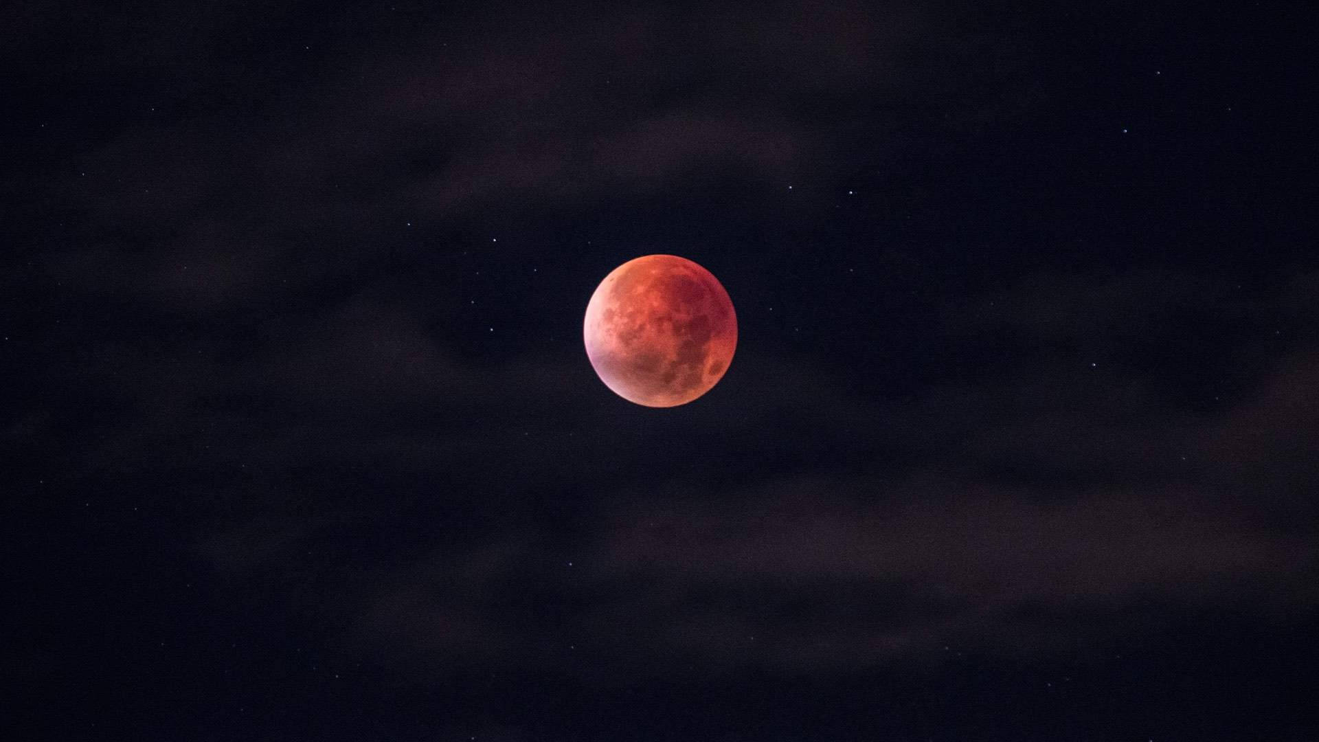 Eclipse 桌布 壁紙 — 血紅色的月亮在佈滿繁星的夜空中被烏雲遮掩，散發出詭異的光芒。